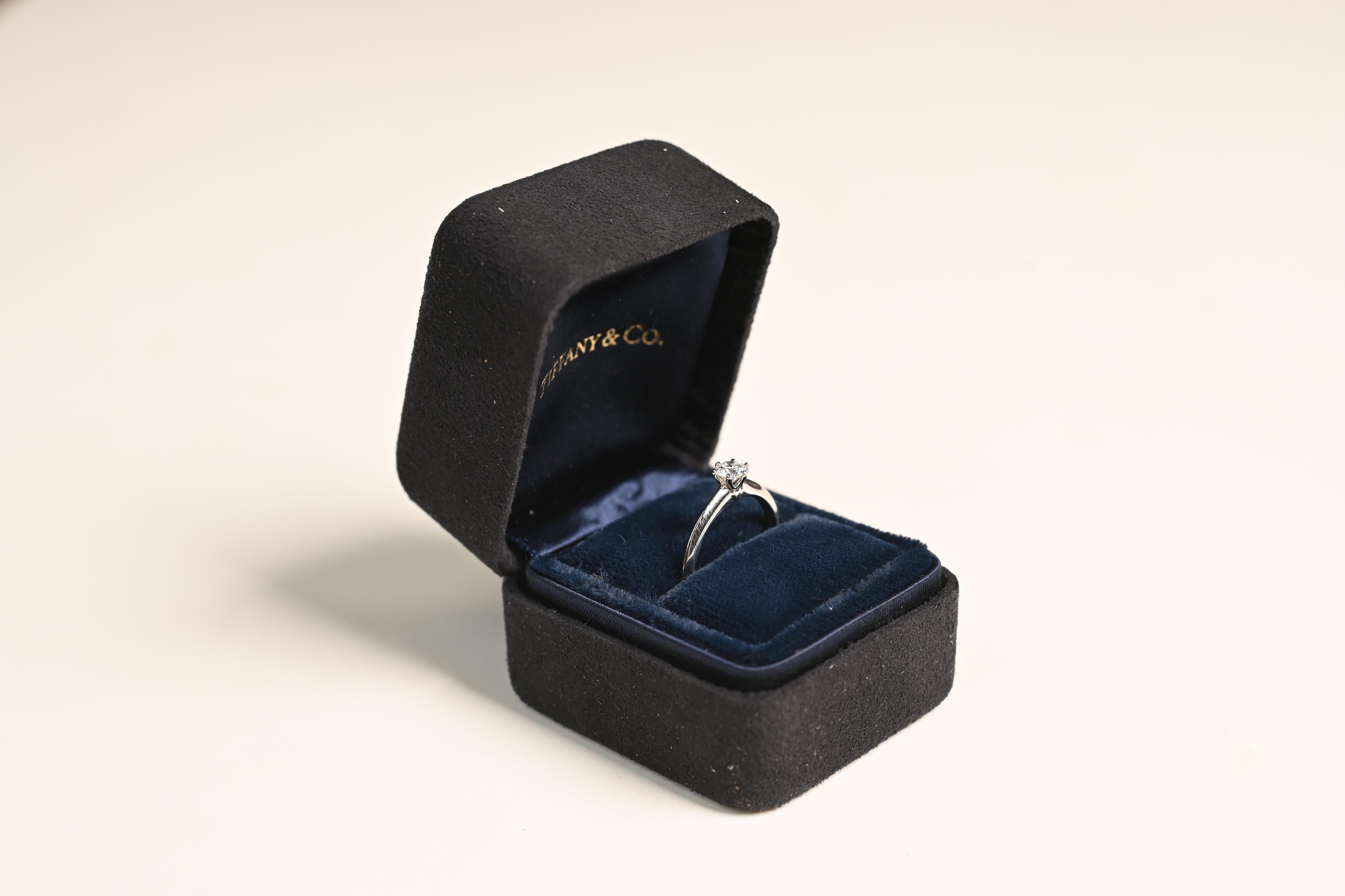 This exquisite Tiffany Ring estate ring showcases a stunning round brilliant-cut diamond weighing approx 0.3-carats. Graded H in color and VVS2 in clarity, the diamond radiates exceptional brilliance and fire. The classic prong setting enhances the