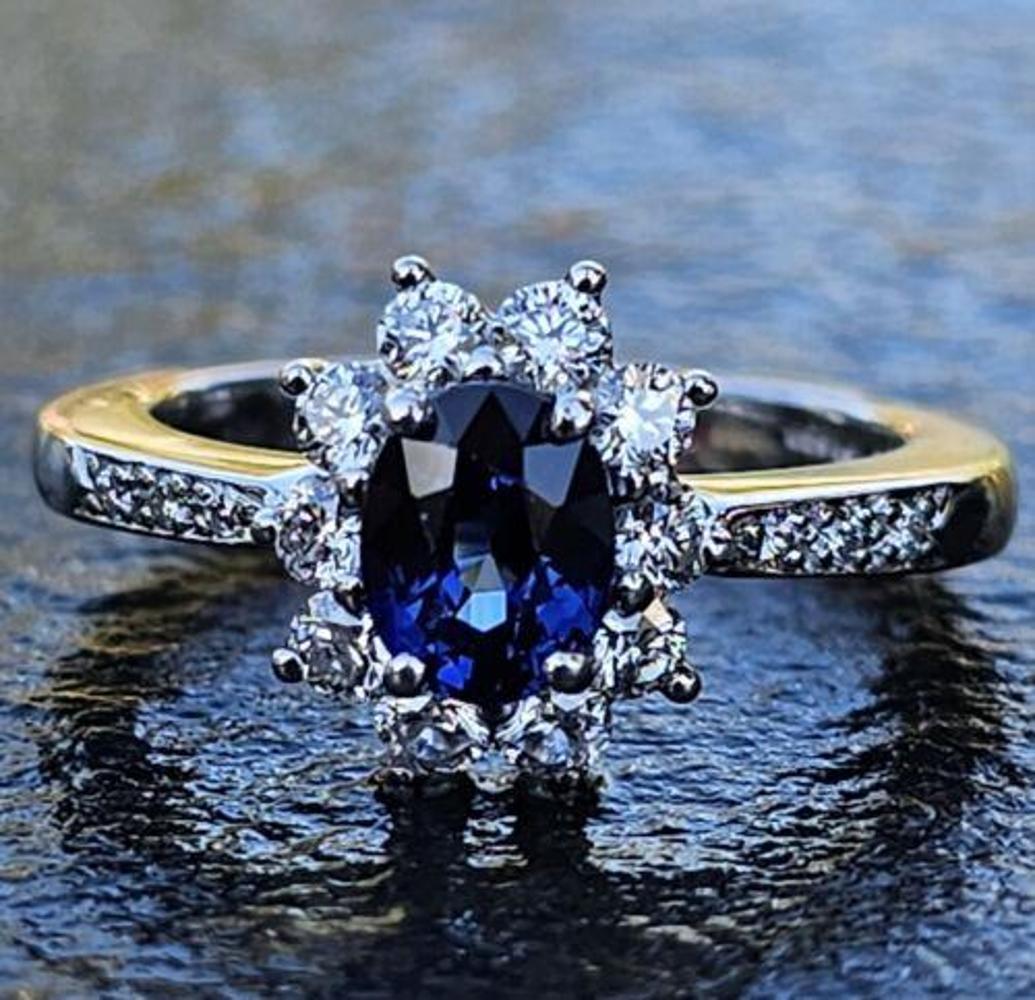 This stunning Tiffany & Co. ring features a beautiful oval-shaped sapphire as the main stone, surrounded by a halo of sparkling diamonds. Crafted from high-quality platinum with a purity of 950, this pre-owned ring is very good used condition. The