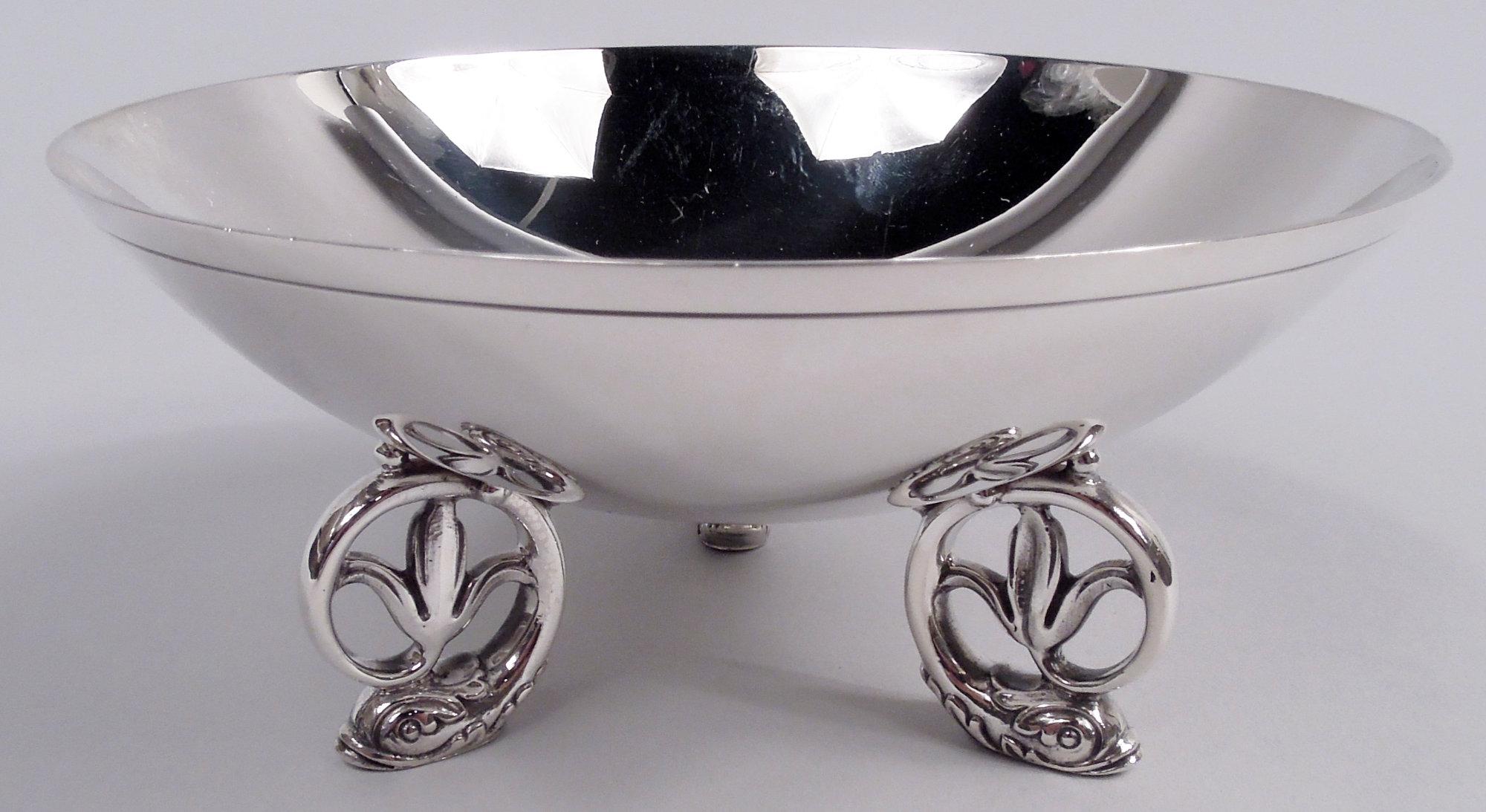 Ciotola moderna in argento sterling. Realizzato da Tiffany & Co. a New York. Rotondo con bordo curvo e lavorato; tre supporti a foglia in fusione a forma di delfino a voluta con terminale a fiore. Design d'ispirazione scandinava del Midcentury.