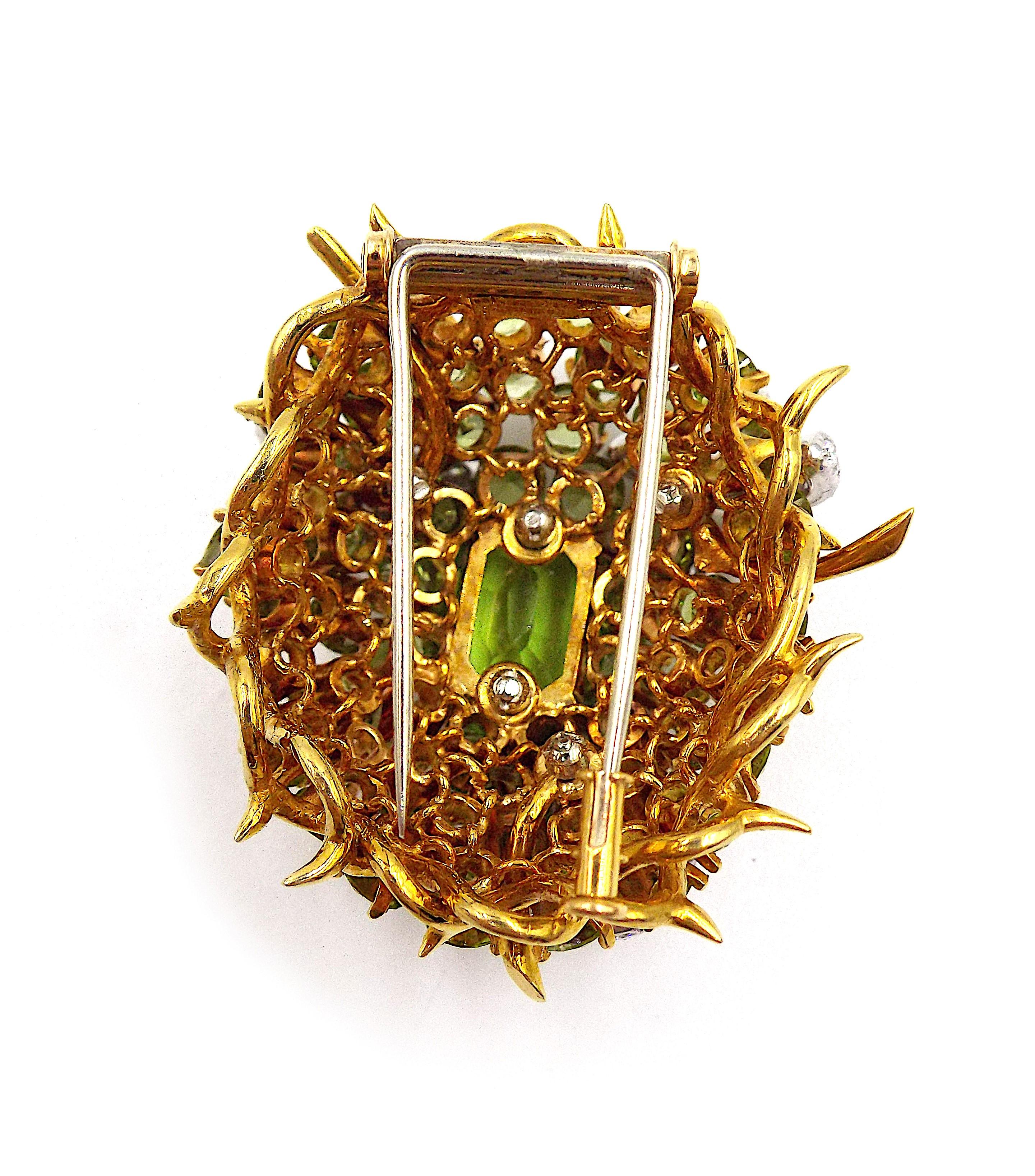 Centered on an oval-shaped peridot, set within a domed surround of round peridots, embellished with three flowerheads, the petals pavé-set with round diamonds, within a border of thorny branches. Center peridot weighs approximately 5.65 carats.
