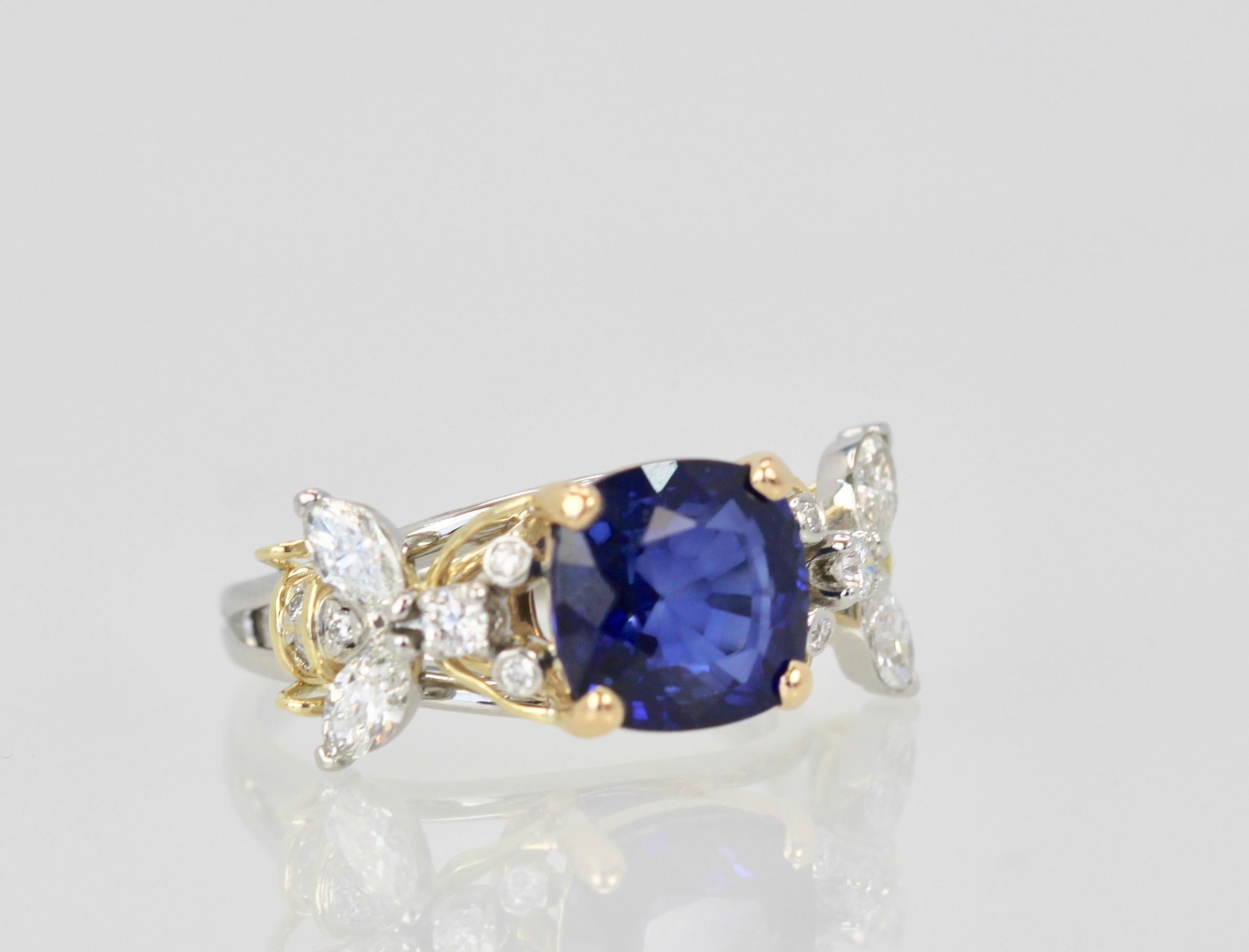 This Tiffany double bee ring with center Sapphire is highly coveted and hard to find.  This ring features a gorgeous Blue Sapphire of 4.39 Carats cushion cut w/ AGI certificate.  There are 4 marquise Diamonds weighting 0.60 carats, round brillant