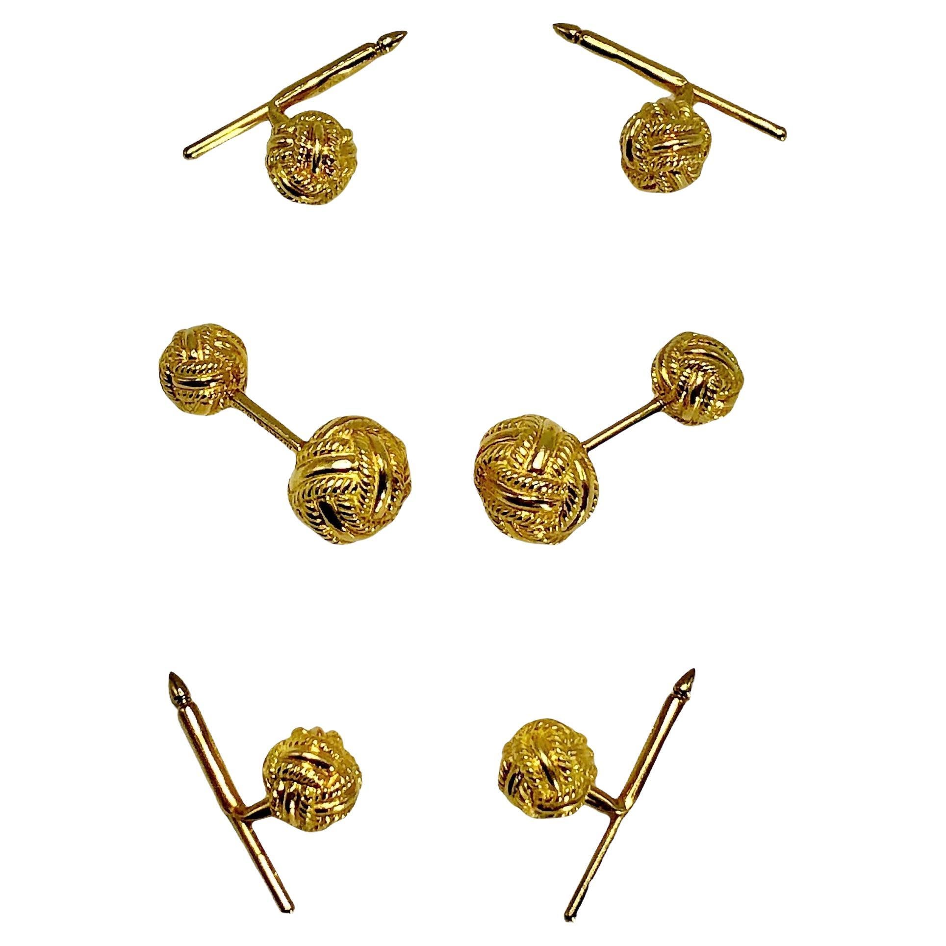 Fashioned from 18k yellow gold in the form of round woven knots, this four button dress set is an iconic model of Tiffany Schlumberger. Each large knot measures a full 1/2 inch in diameter and all small knots have diameters of 1/3 inches.  The cuff