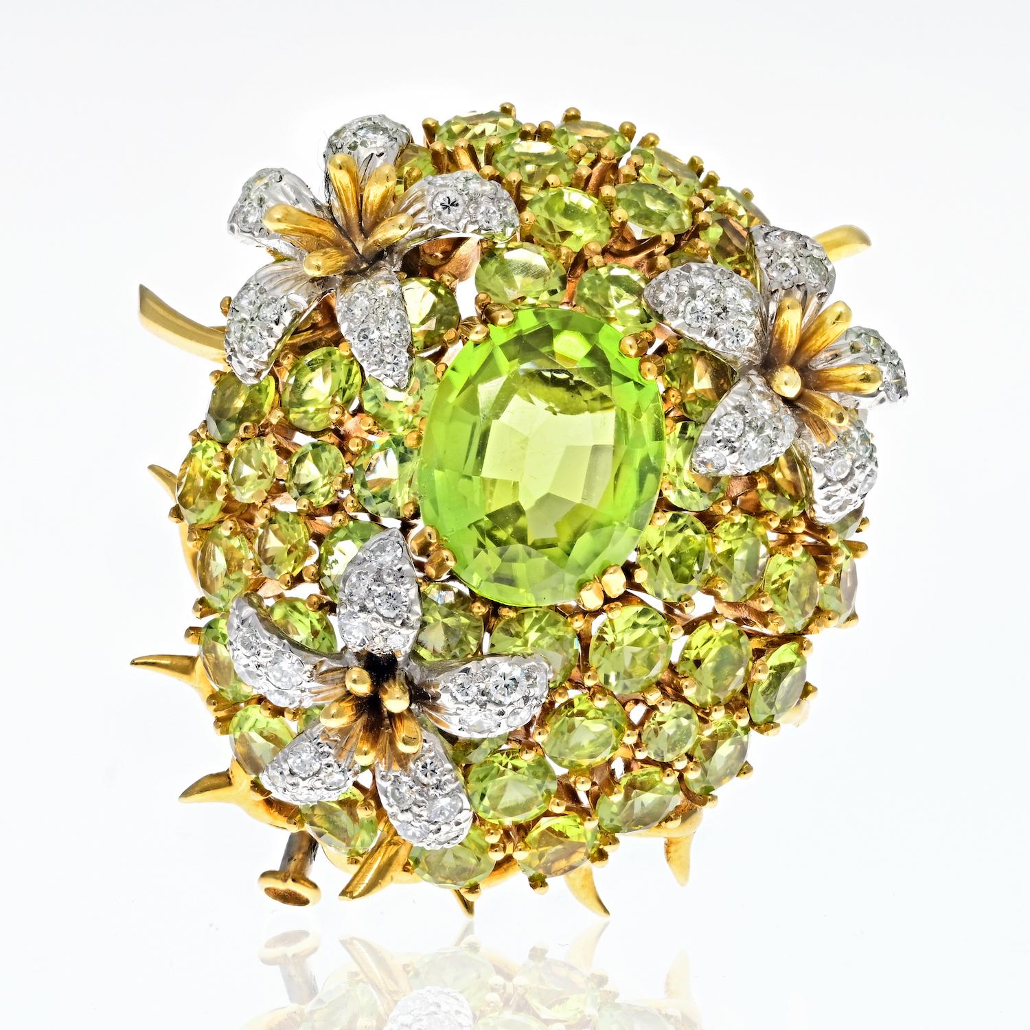 Tiffany & Co. Schlumberger Platinum & 18K Yellow Gold Oval Cut Peridot And Diamond Brooch.

Centered on an oval-shaped peridot, set within a domed surround of round peridots, embellished with three flowerheads, the petals pavé-set with round