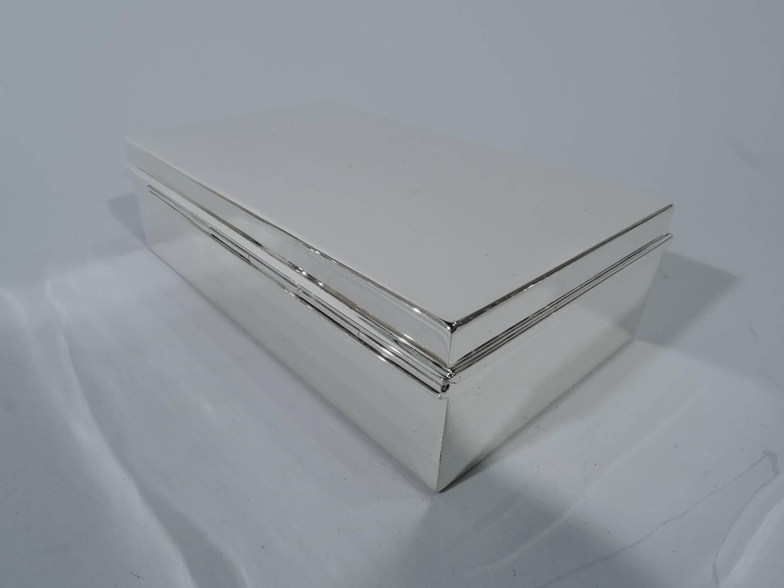 Smart and Modern sterling silver desk box. Made by Tiffany & Co. in New York. Rectangular with straight sides. Cover is hinged and has molded rim. Box interior cedar lined. Cover interior lightly gilt. Hallmark includes pattern no. 22354 and