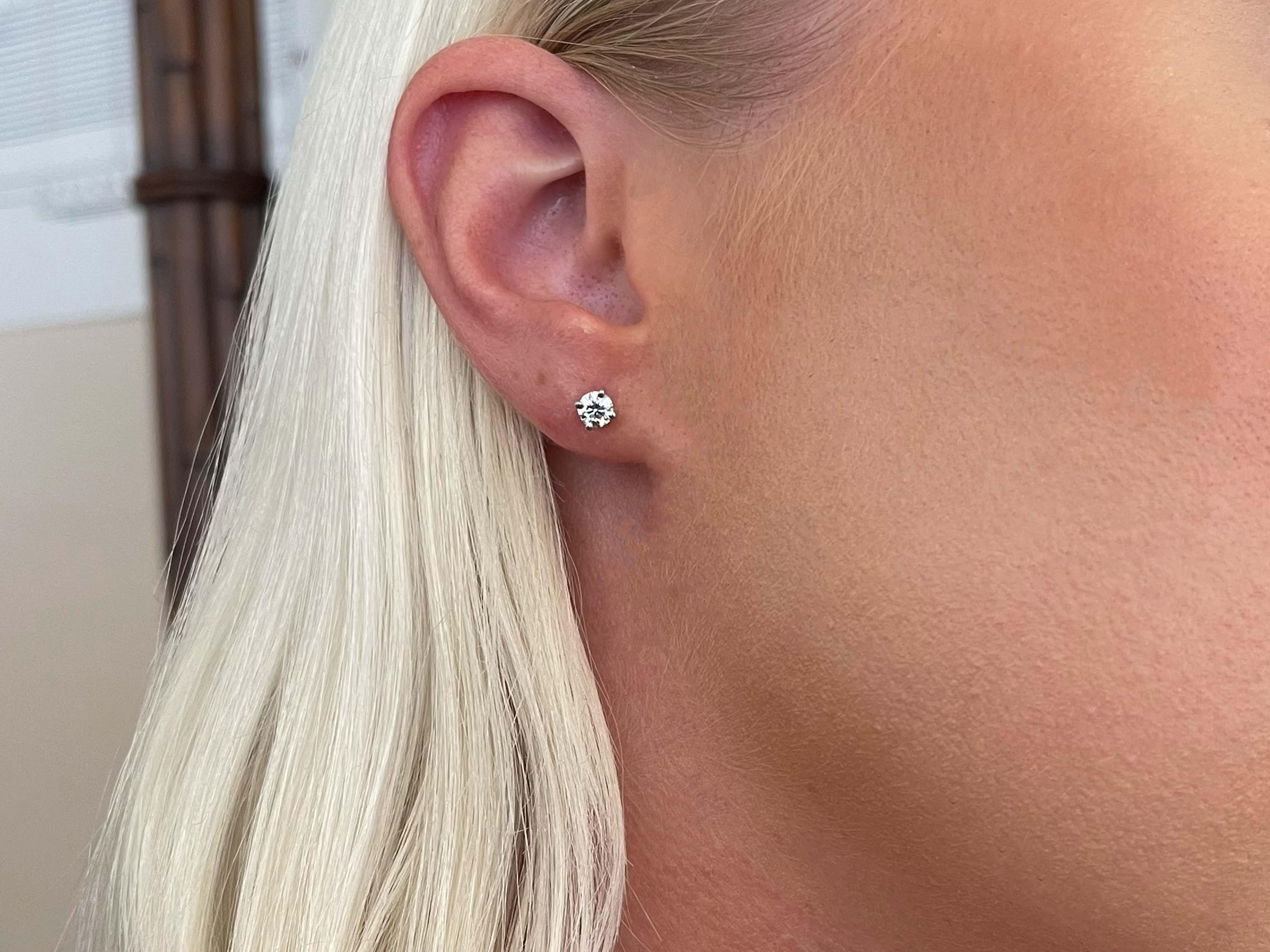 These gorgeous earrings each feature a round brilliant cut diamond prong set, with a total carat weight of 0.58 carats. The diamonds are H, VS2 and have beautiful sparkle. These earrings are beautifully crafted in platinum with a high polished