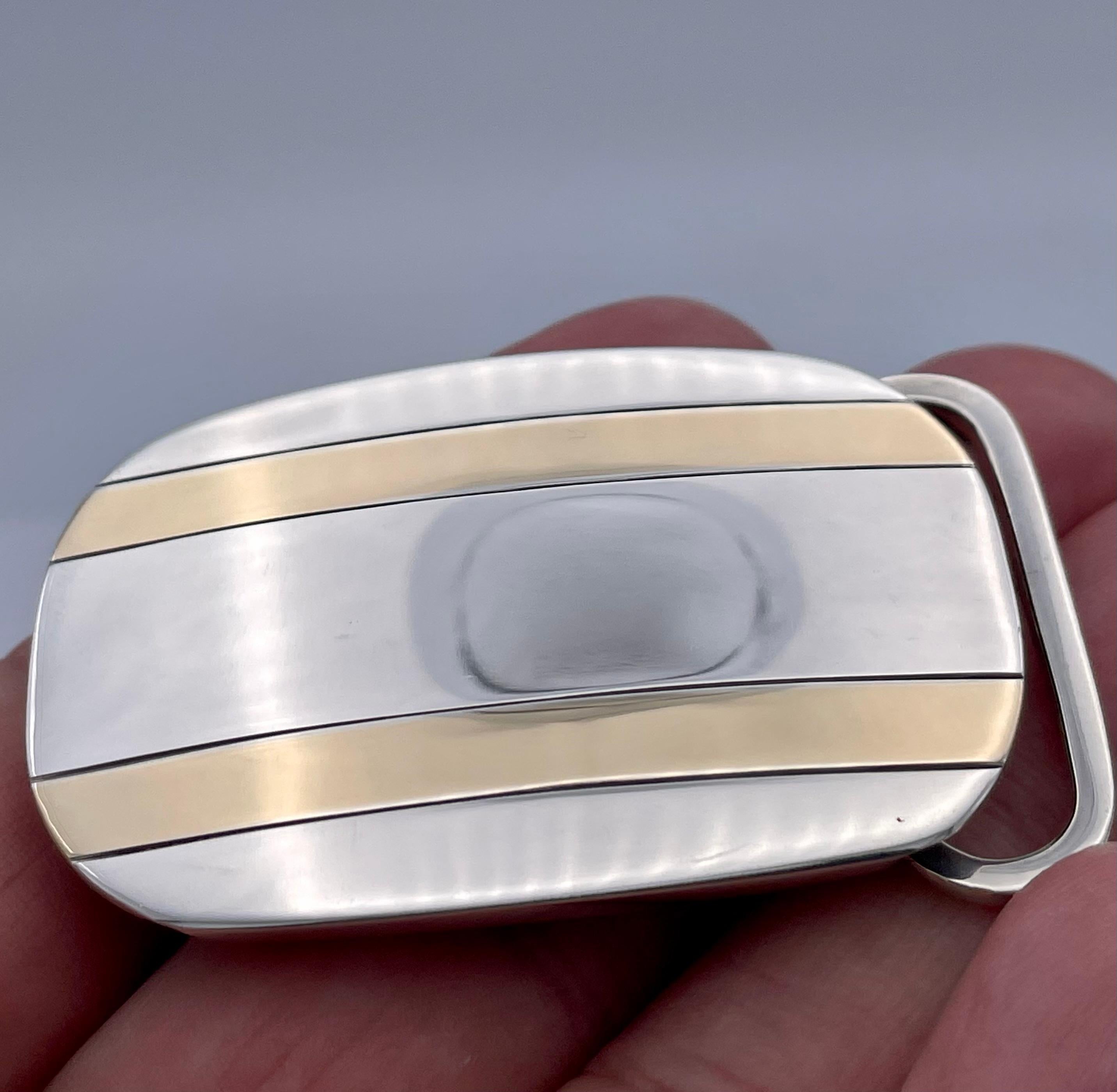 Handsome belt buckle.  Made and signed by TIFFANY & CO.  Sterling silver with two parallel 14K yellow gold inset lines.  2