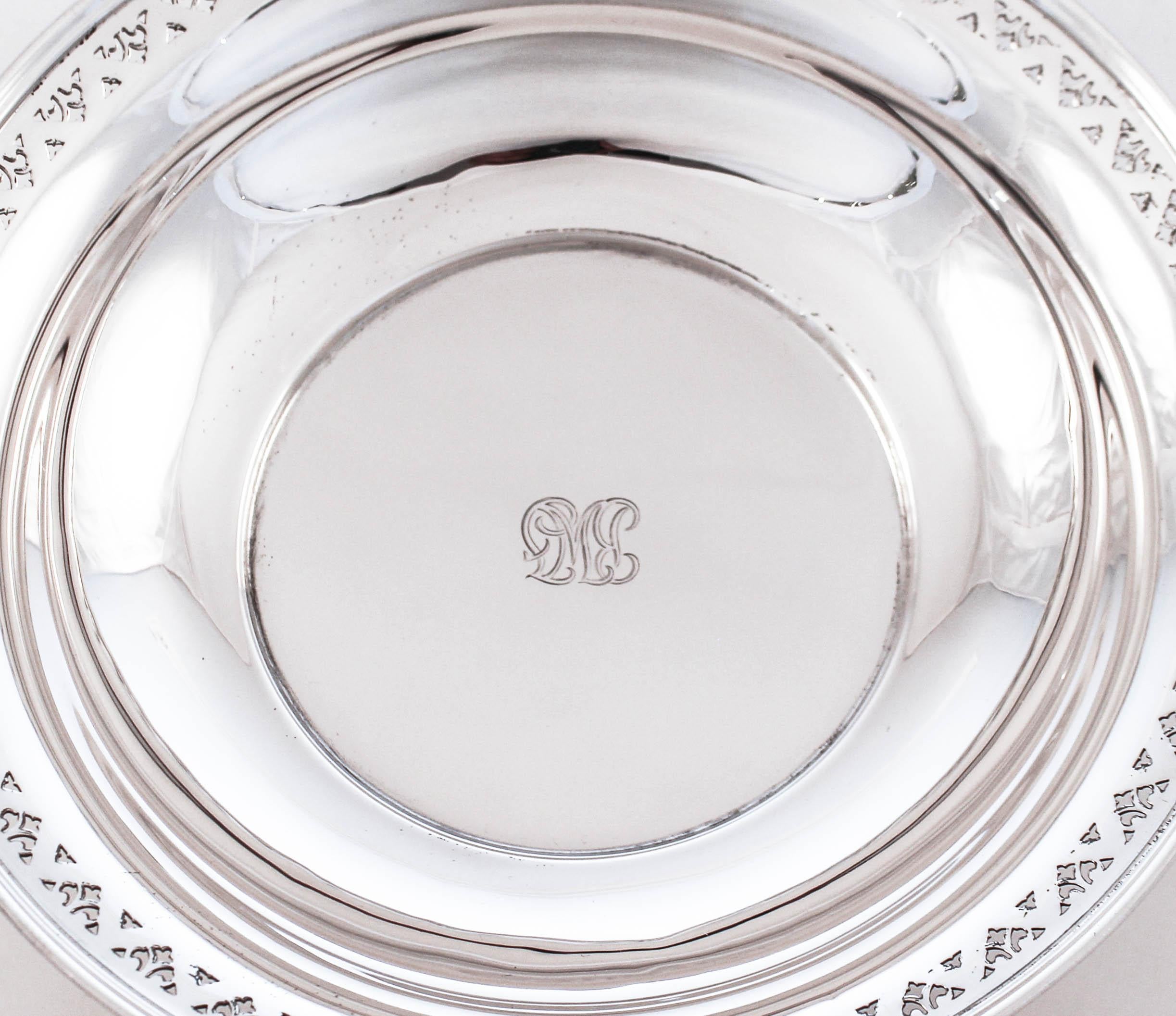 Being offered is a sterling silver bowl by Tiffany & Co. It has a symmetrical cutout pattern going around the edge. It’s a great size for fruit or desserts. In the center there is a hand engraved monogram in the distinctive Tiffany style.