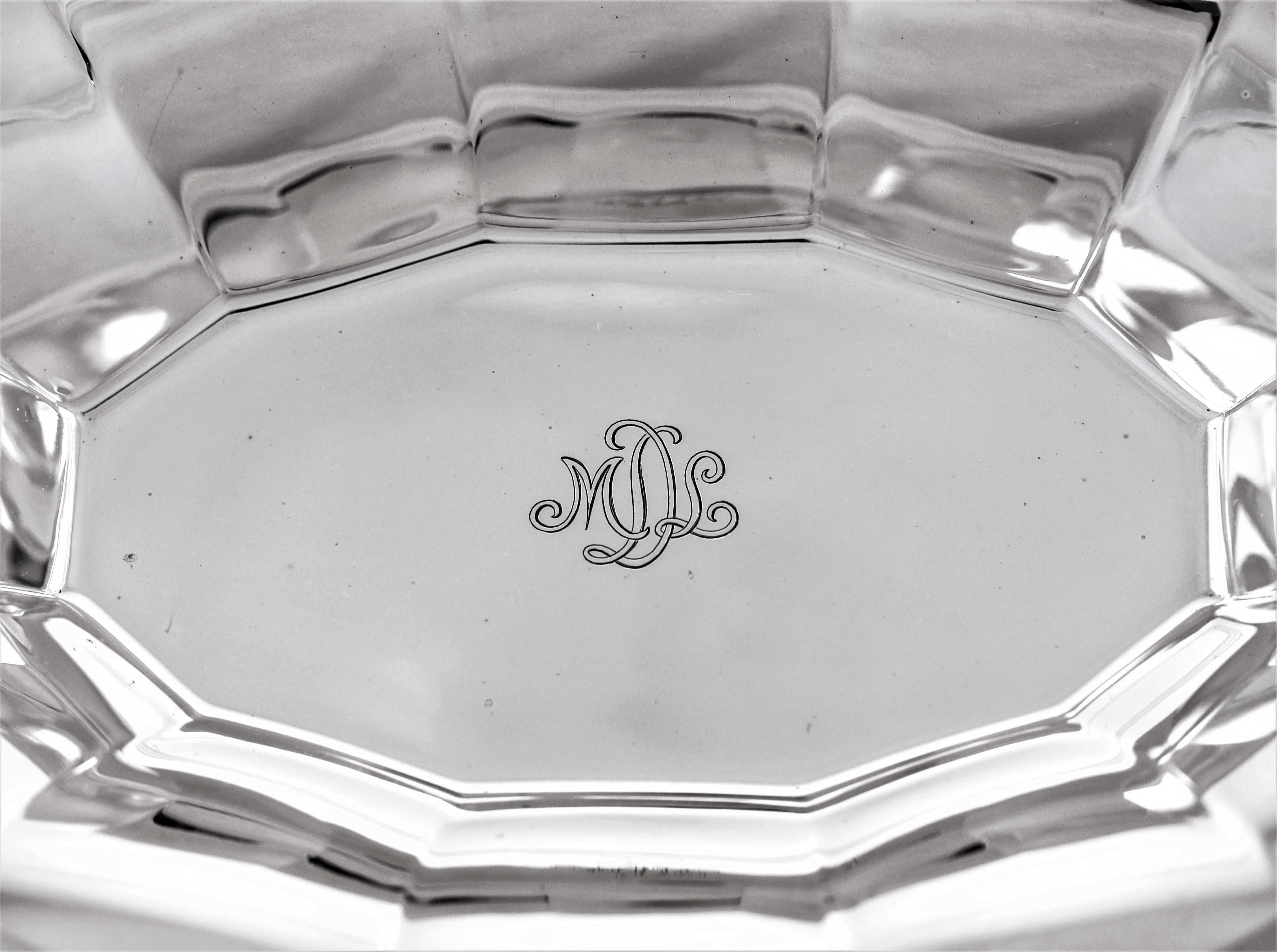 A large scalloped rim encircles the entire circumference. Along the inside, ridges at each point where the scalloping dips. In the centre a hand engraved monogram of the letters MDL in script. This piece has a modern youthful look and can be used