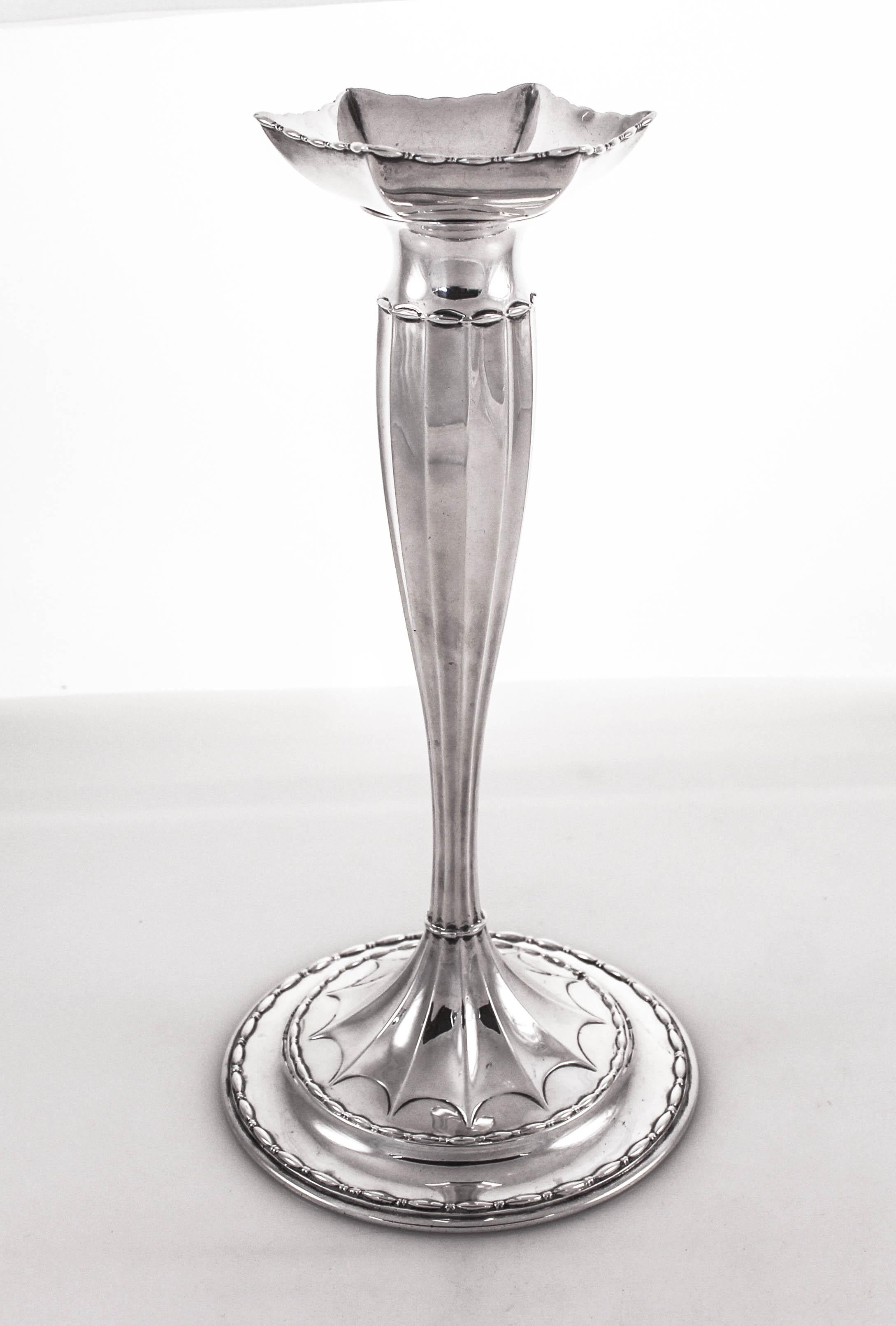 We are proud to offer this pair of sterling silver candlesticks by Tiffany and CO. They have a tapered shape with a round not weighted base. The bobeche has a hexagon shape and is removable. Around the base a web-like pattern compliments the