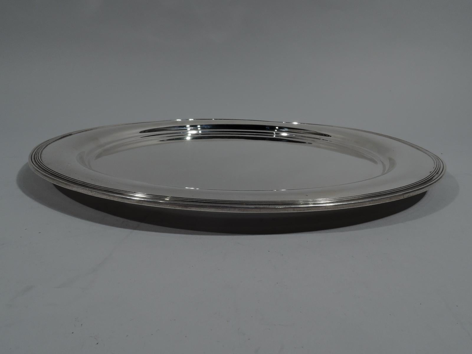 Modern sterling silver serving tray. Made by Tiffany & Co. in New York, circa 1920. Round well, curved shoulder, and reeded rim. Fully marked including pattern no. 5765, director’s letter m (1907-1947), and diameter. Weight: 33 troy ounces.