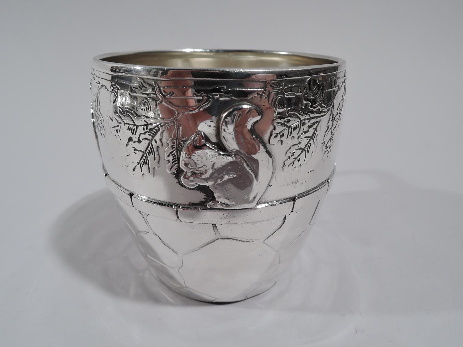 Edwardian sterling silver baby cup. Made by Tiffany & Co. in New York, circa 1911. Barrel form with bracket handle. At top is acid-etched frieze with leafing oak branch and acorn-nibbling squirrels seated on applied flat stone girdle supported by