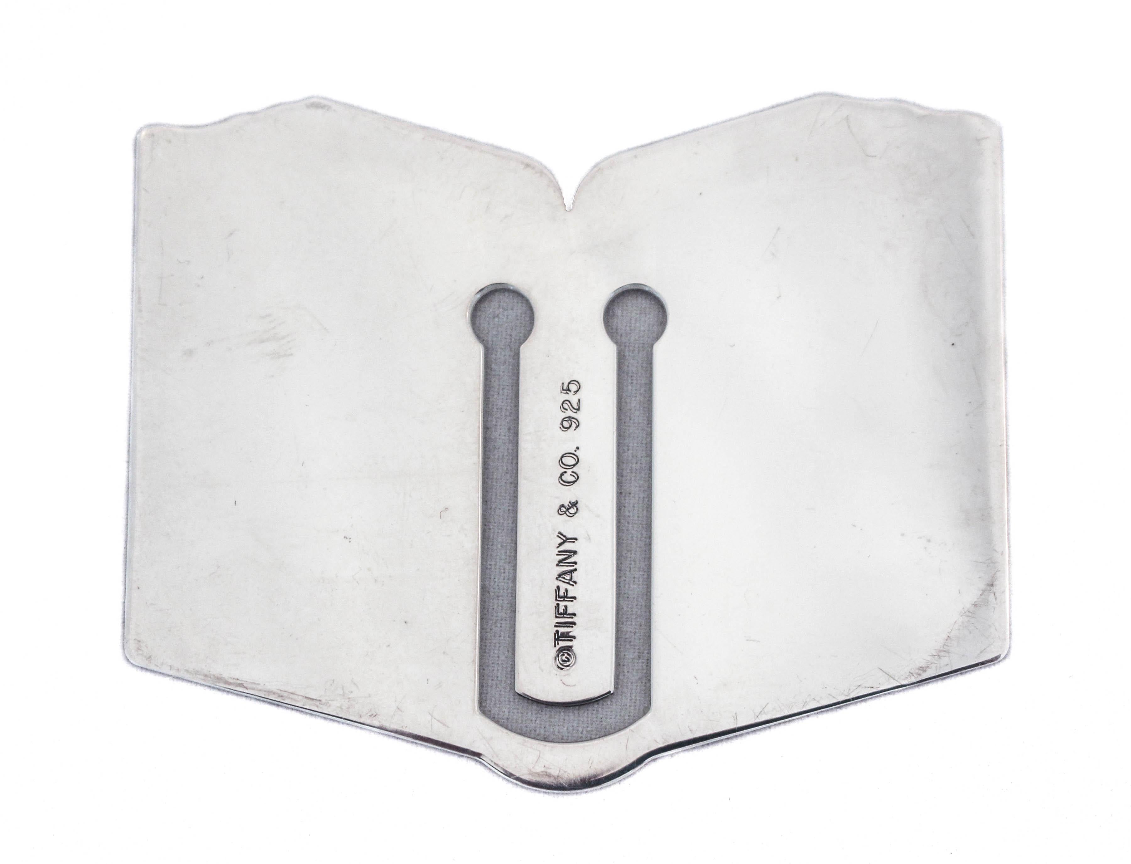 We are happy to offer you this sterling silver bookmark by the world renowned Tiffany & Company. It is a bookmark in the shape of an open book! Along the top the lines are designed to mimic pages in a book. A great gift for that someone who has