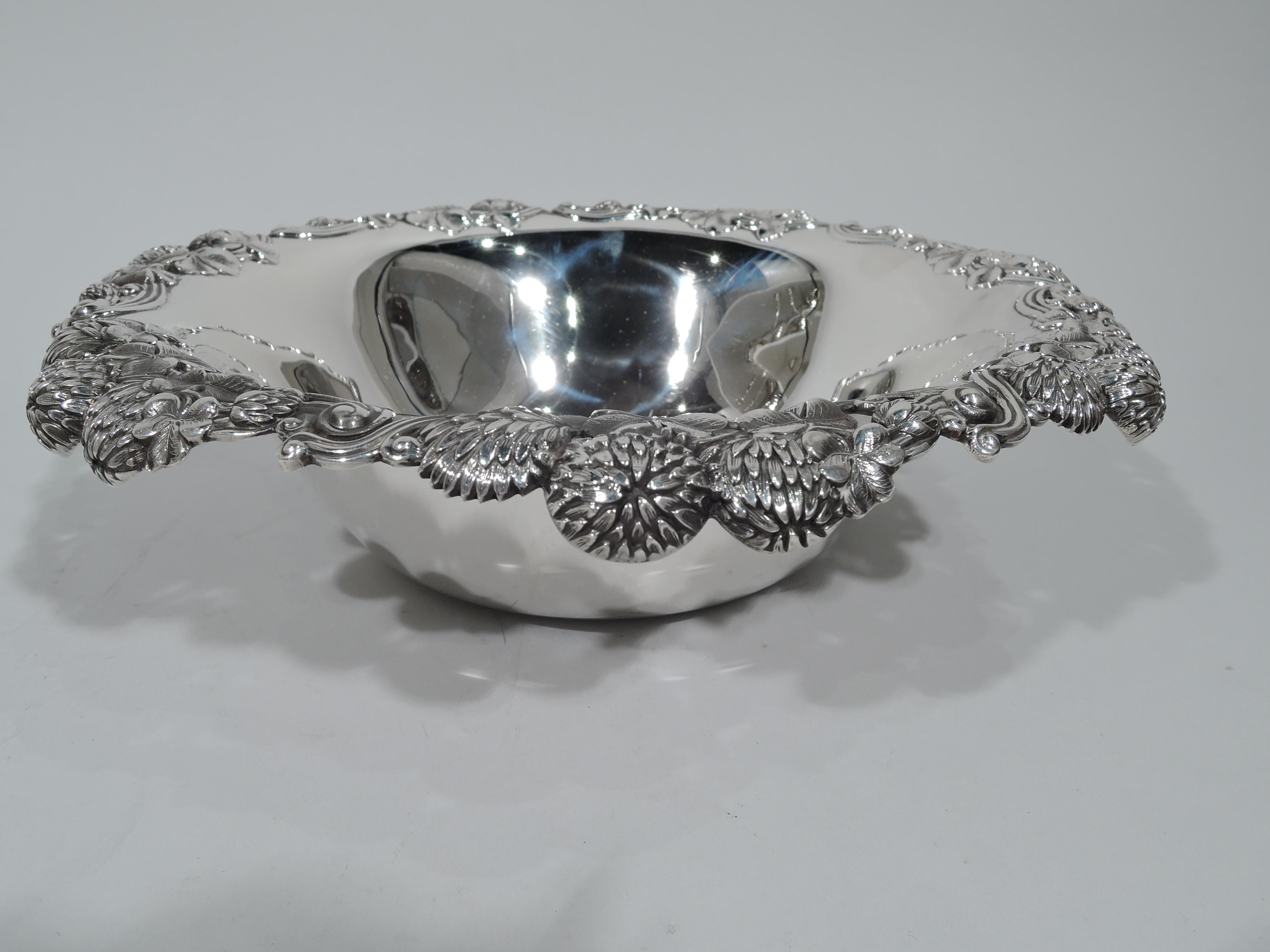 Sterling silver bowl in Classic clover pattern. Made by Tiffany & Co. in New York, circa 1910. Tapering sides and turned-down rim with bunched blossoms. An early piece in this Gilded Age high-low pattern that combines wild flowers and precious