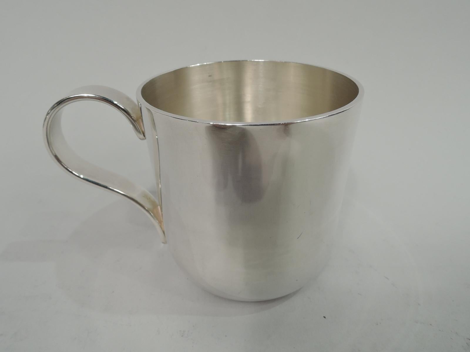 Modern sterling silver baby cup. Imported to England in 1993 by Tiffany & Co. in London. Straight sides with curved bottom and scrolled handle. On front is tooled jack-in-the-box heightened with enamel. Marked “925 [in oval] / Tiffany & Co.” with