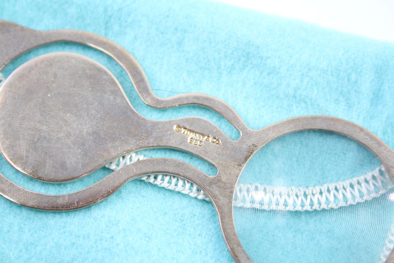 TIFFANY & CO. Segnalibro e lente d'ingrandimento in argento sterling, modello occhiali, con timbro 925 e peso di circa 13 g, lunghezza 9 cm.
viene fornito con una custodia tiffany. In condizioni generali molto buone, con i soliti piccoli segni
