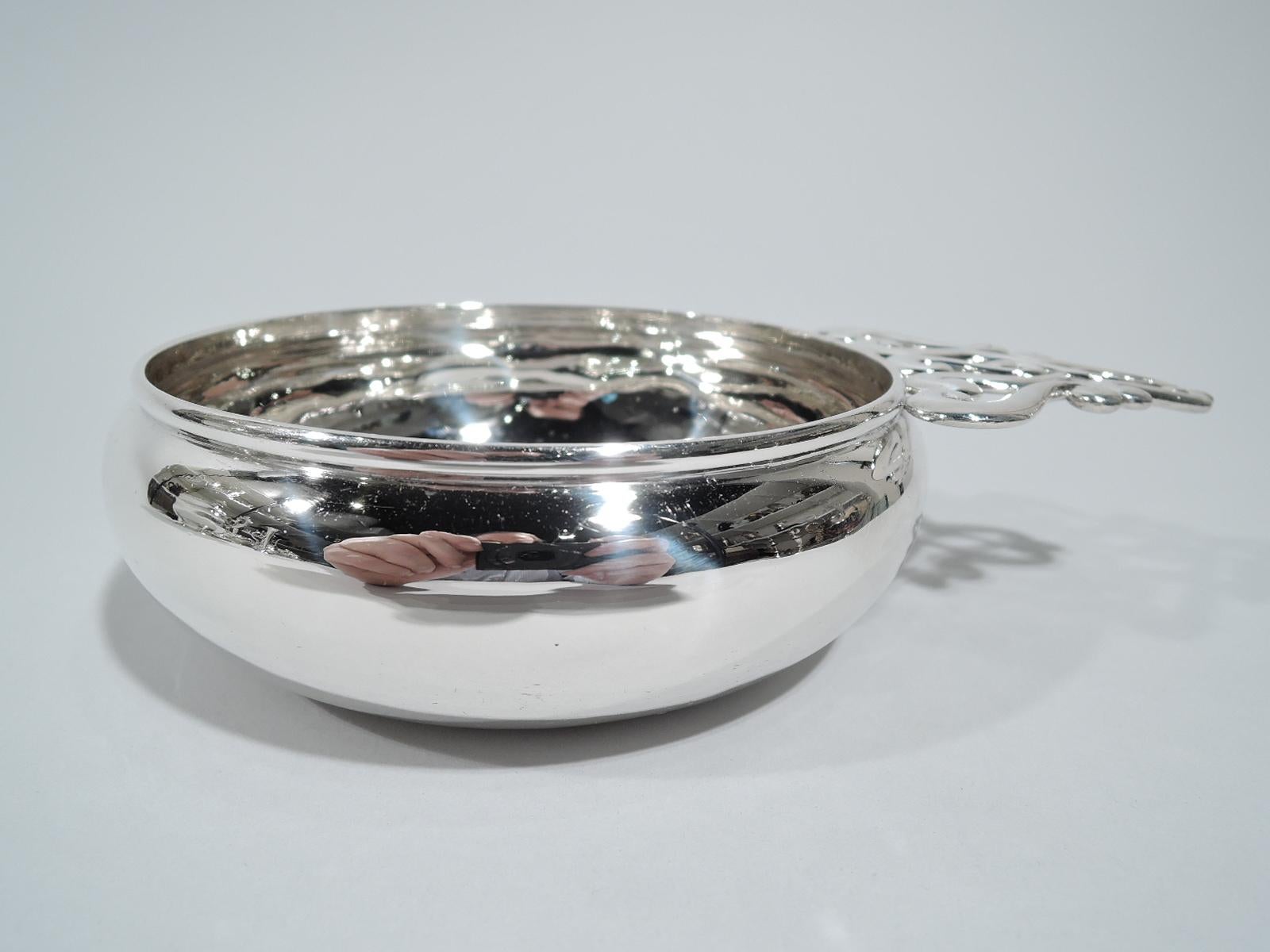 Edwardian sterling silver porringer. Made by Tiffany & Co. in New York. Traditional curved bowl. Unusual open handle comprising S-scrolls. Fully marked including pattern no. 12755A and director’s letter C (1902-1907). Weight: 7 troy ounces.