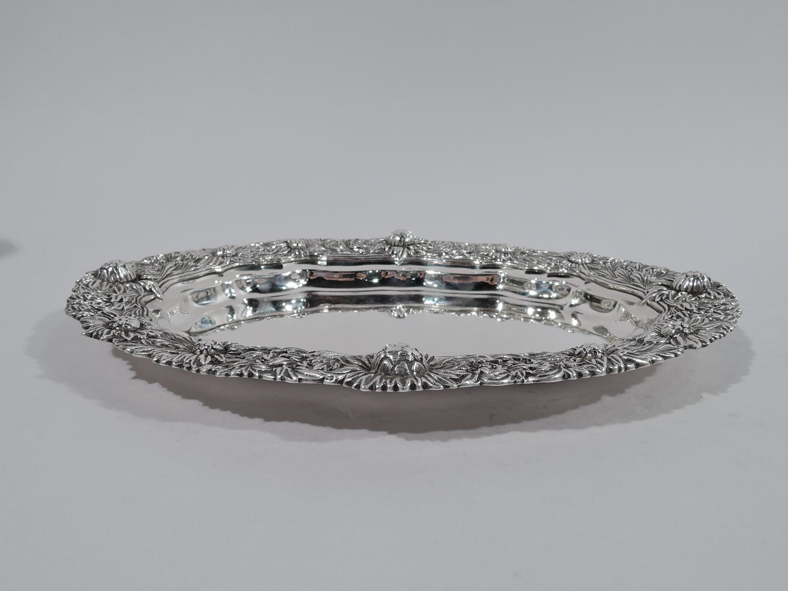 Chrysanthemum sterling silver serving platter. Shaped oval well surrounded by profusion of dense and tactile flowerheads with irregular rim. A very nice in the desirable Japonesque pattern that was introduced in 1880. Fully marked including pattern