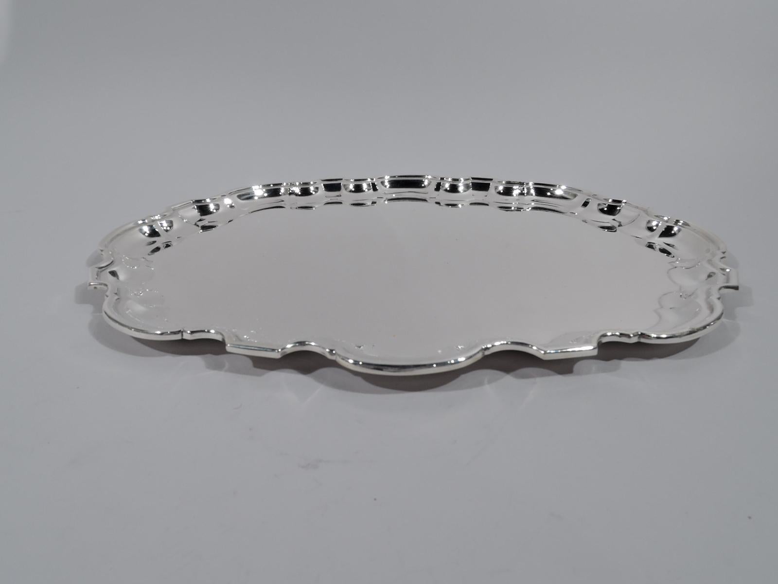 Georgian-style sterling silver tray. Made by Tiffany & Co. in New York. Ovalish with molded and curvilinear piecrust rim. A great piece in the traditional style in a hard-to-find shape. Hallmark includes postwar pattern no. 25119. Heavy weight: 41.5