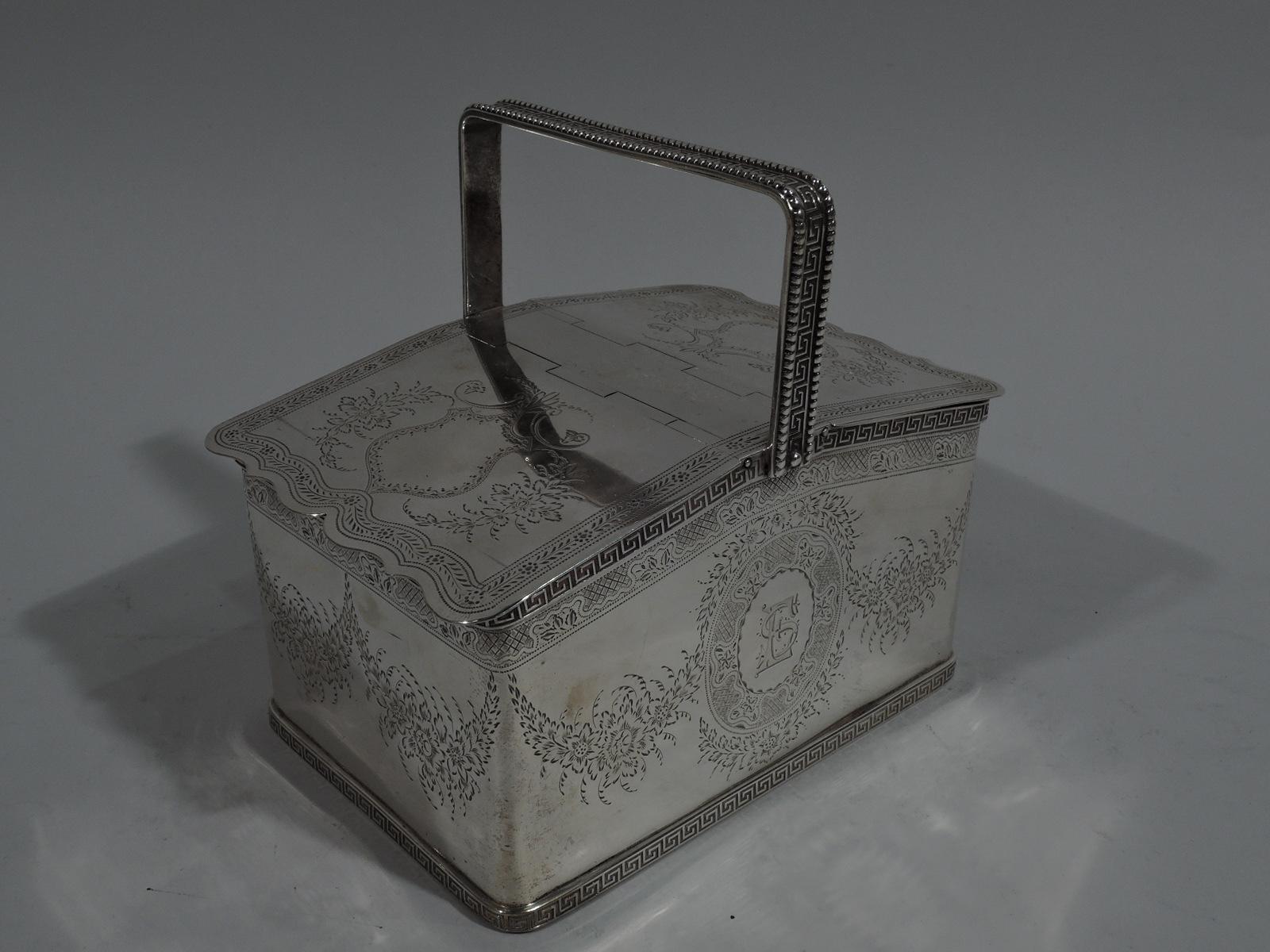 Regency Revival sterling silver tea caddy. Retailed by Tiffany & Co. at 550 Broadway, New York. Rectangular with straight sides and curved corners. Sloping rim and hinged and overlapping double covers with cutout scrolled rims. Stationary bracket