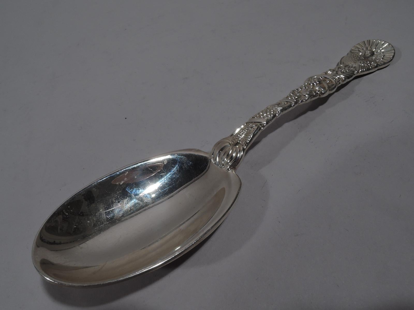 Thanksgiving sterling silver serving spoon. Retailed by Tiffany & Co. in New York. Dense double-sided ornament. Terminal is turkey-form and handle has fruits and flowers spilling out of cornucopia. Bowl oval and plain. A hearty, hefty seasonal