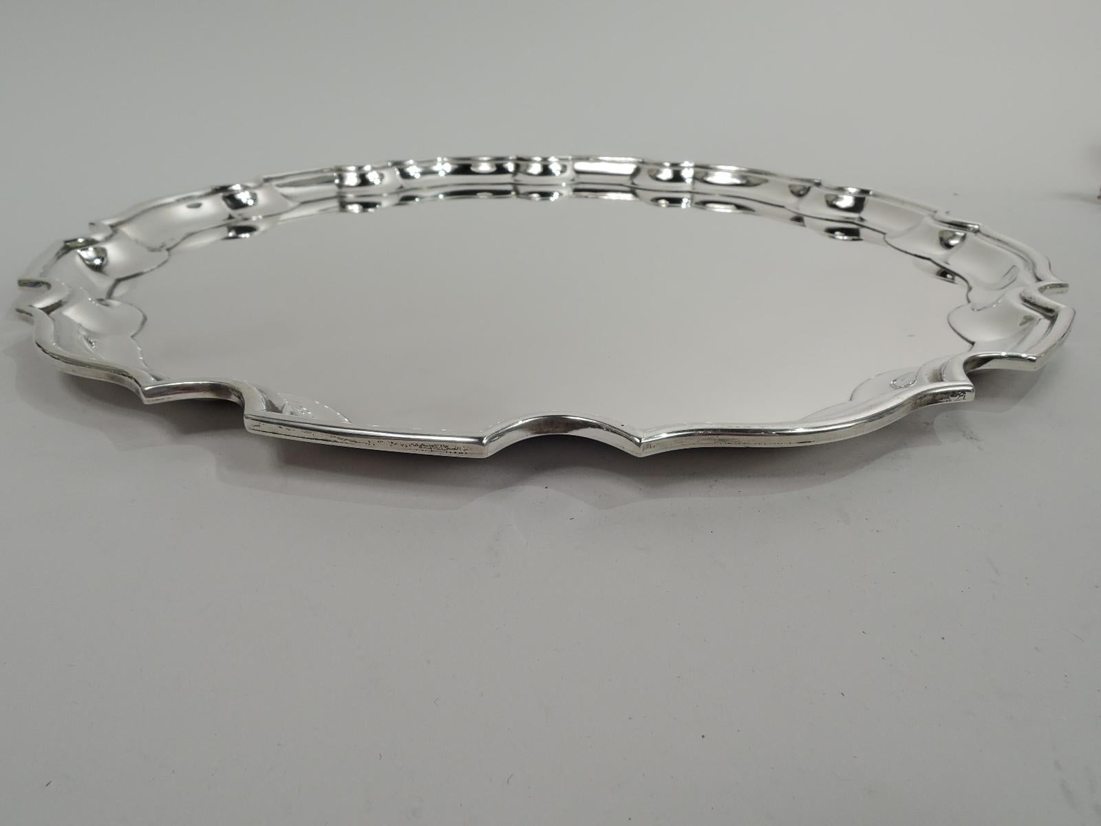 Traditional Georgian sterling silver tray. Made by Tiffany & Co. in New York. Round with crisp and molded curvilinear piecrust rim. Fully marked including maker’s stamp and postwar pattern no. 24072. Heavy weight: 36.5 troy ounces.