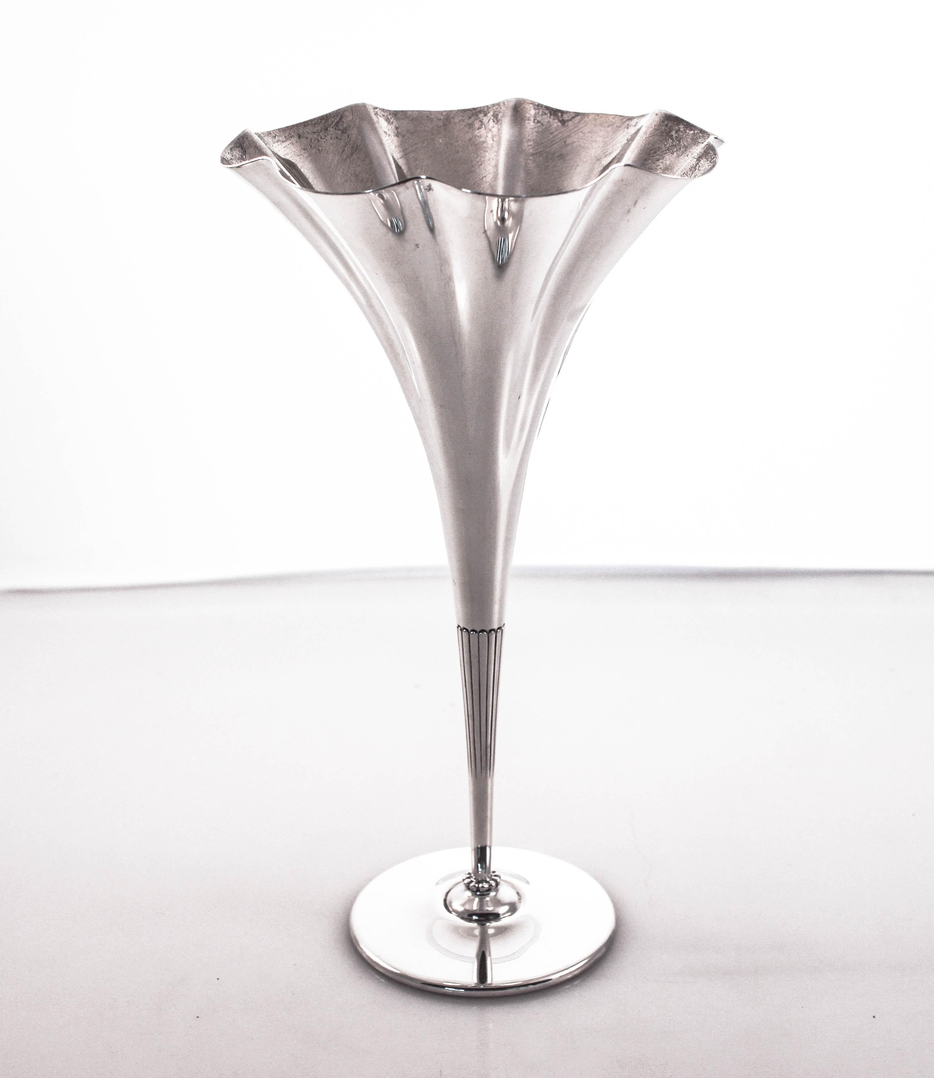 We are delighted to offer this sterling silver vase made by the renowned Tiffany & Co. It has a fluted rim and is tapered, giving the illusion of a blossoming flower. It’s the perfect size vase for a powder or bedroom. Just a few flowers to brighten