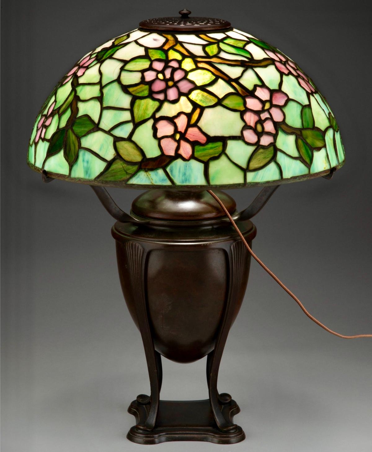Tiffany Studios Apple Blossom Leaded Glass and Bronze Table Lamp, The patinated bronze base with with Acorn design in wonderful condition gives a great stature to the pink floral apple blossoms.
Apple Blossom Table Lamp, circa 1910
USA, New