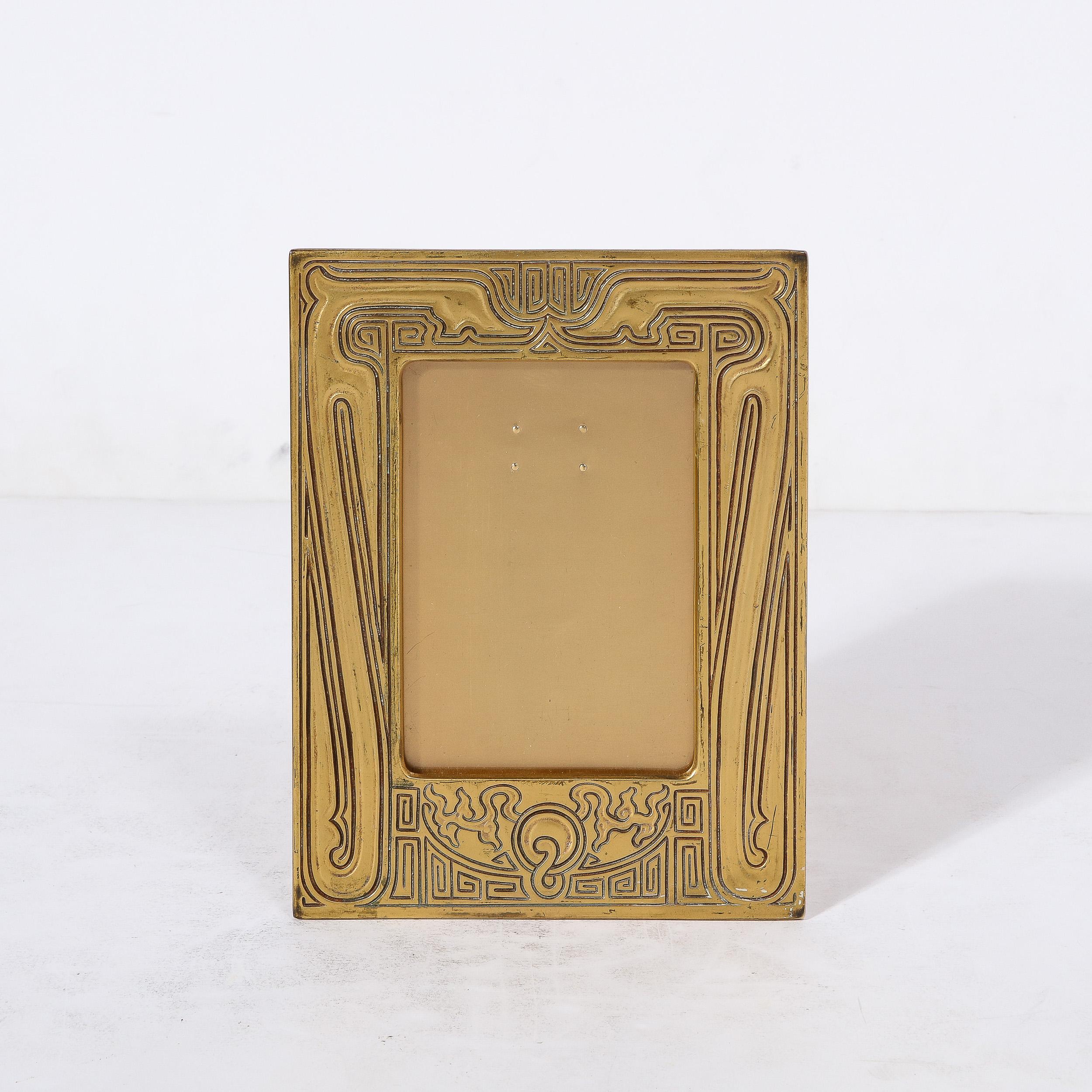 This elegant and stunningly made Tiffany Studios Chinese Pattern Gilt Bronze Picture Frame Originates from the United States, Circa 1920. A part of their Chinese pattern, this picture frame features a beautiful design motif in grooved linework,