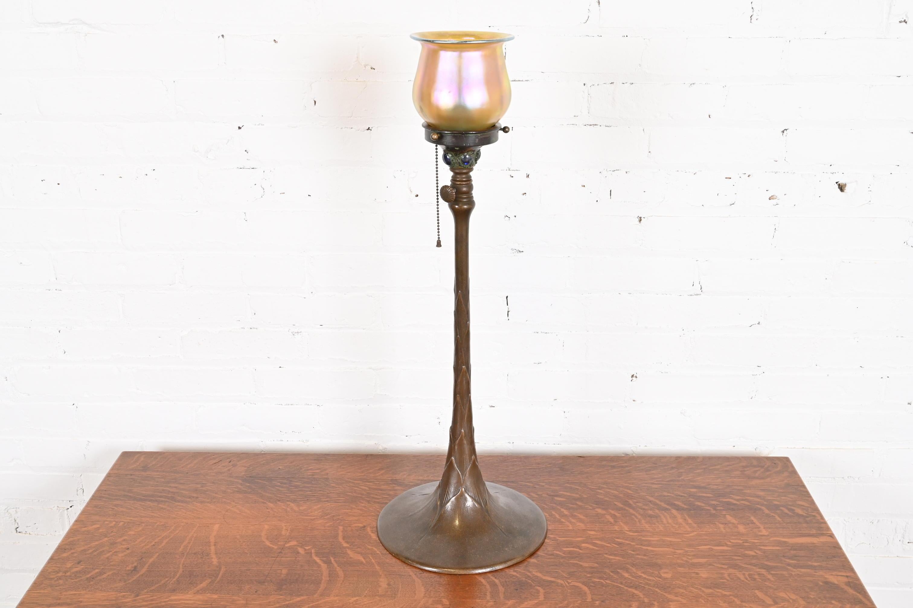 A beautiful Arts & Crafts period adjustable floor lamp

By Tiffany Studios

New York, USA, Early 20th Century

Patinated bronze stand in artichoke form, with gorgeous favrile glass shade signed L.C.T.

Measures: 10