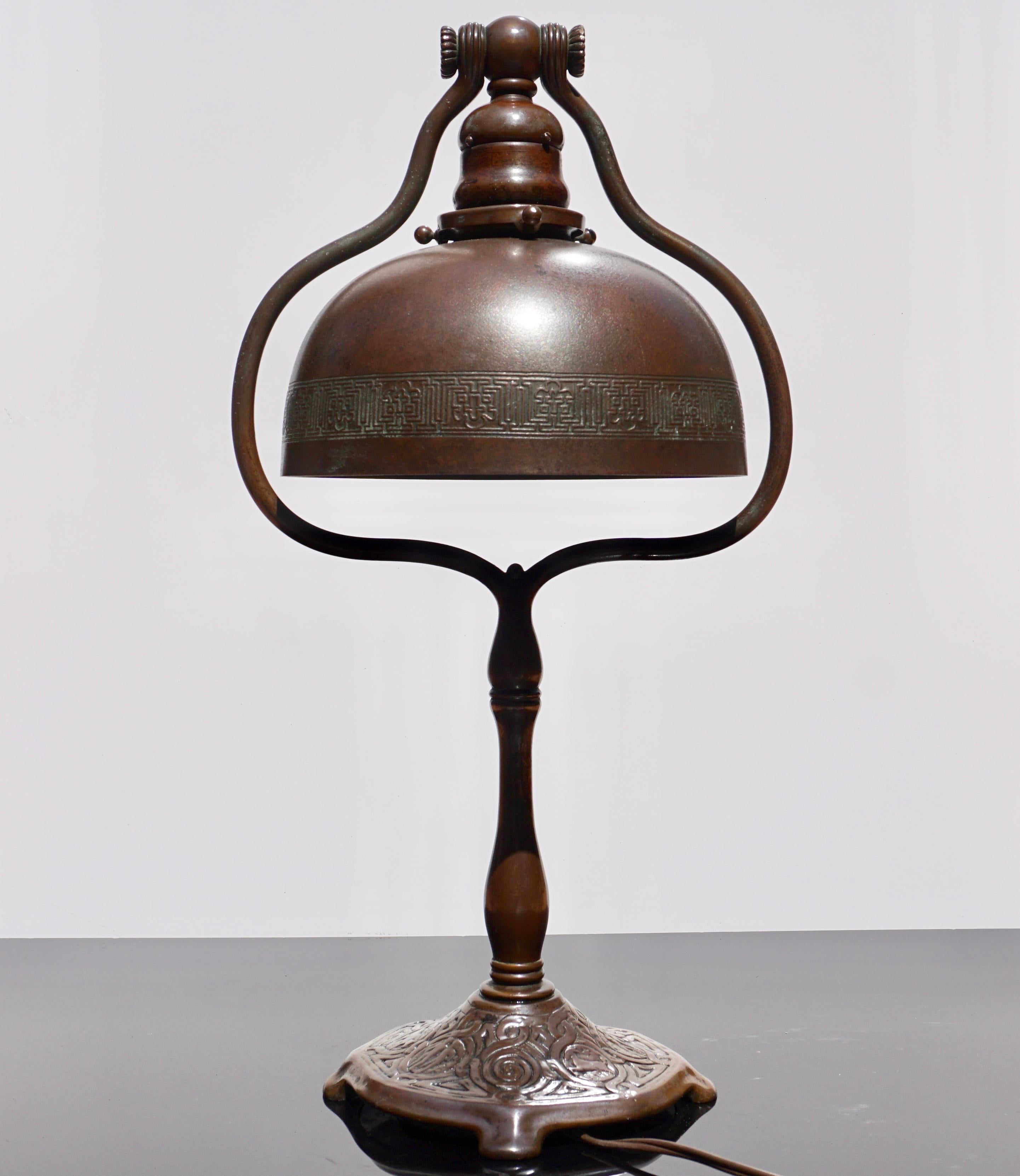 A wonderful Art Nouveau chocolate brown patinated bronze decorated desk lamp, circa 1918. A staple Tiffany Studios tall harp design with shade and base properly signed. Perfect for your studio, office, living room or bedroom! Wonderful antique