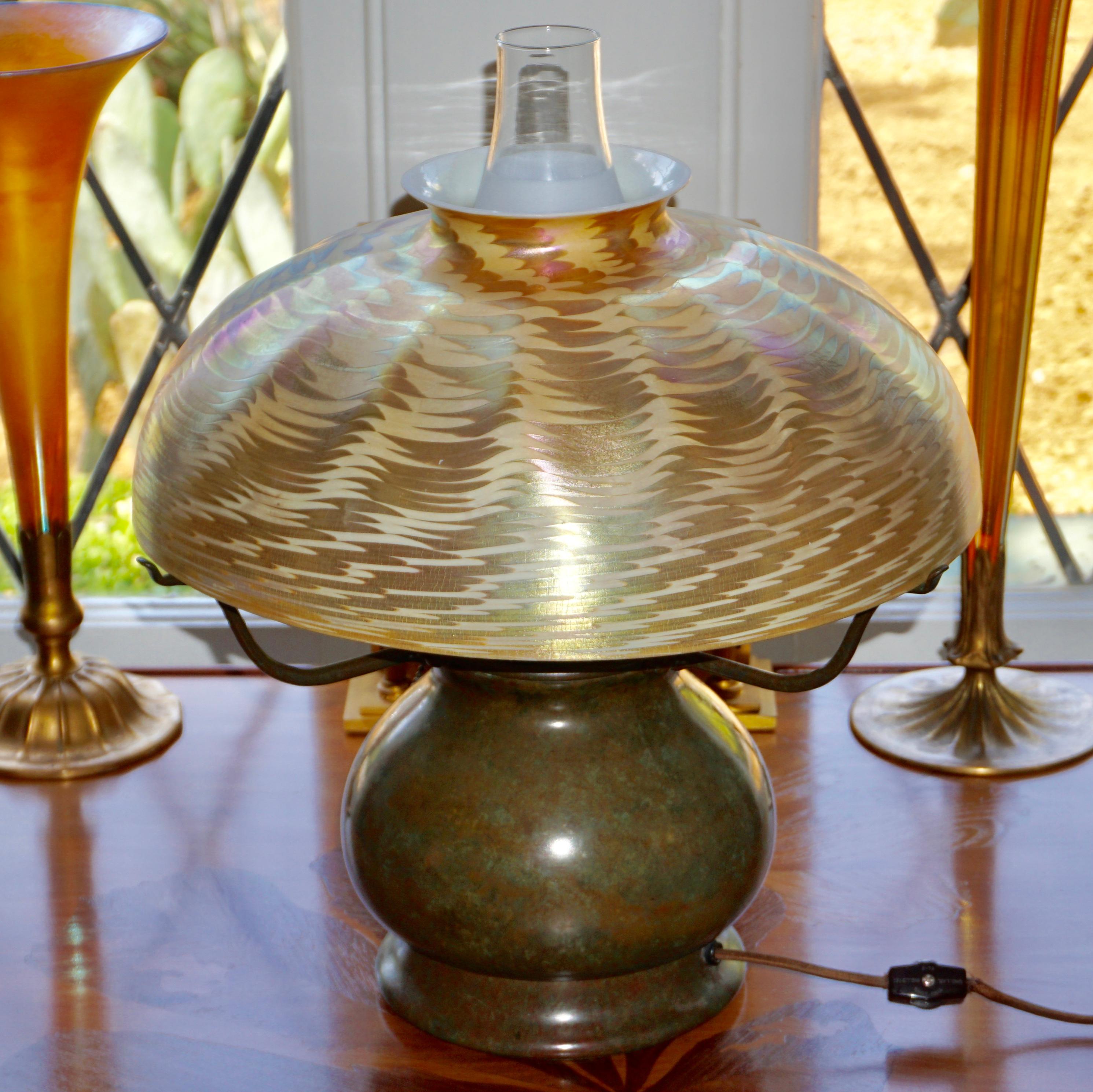 Cette lampe de table Tiffany Studios a un très grand et magnifique abat-jour en damasquine or et argent. Le motif damassé se détache sur un fond de couleur crème et les irisations argentées et dorées présentent de jolis éclats de rose, d'orange et