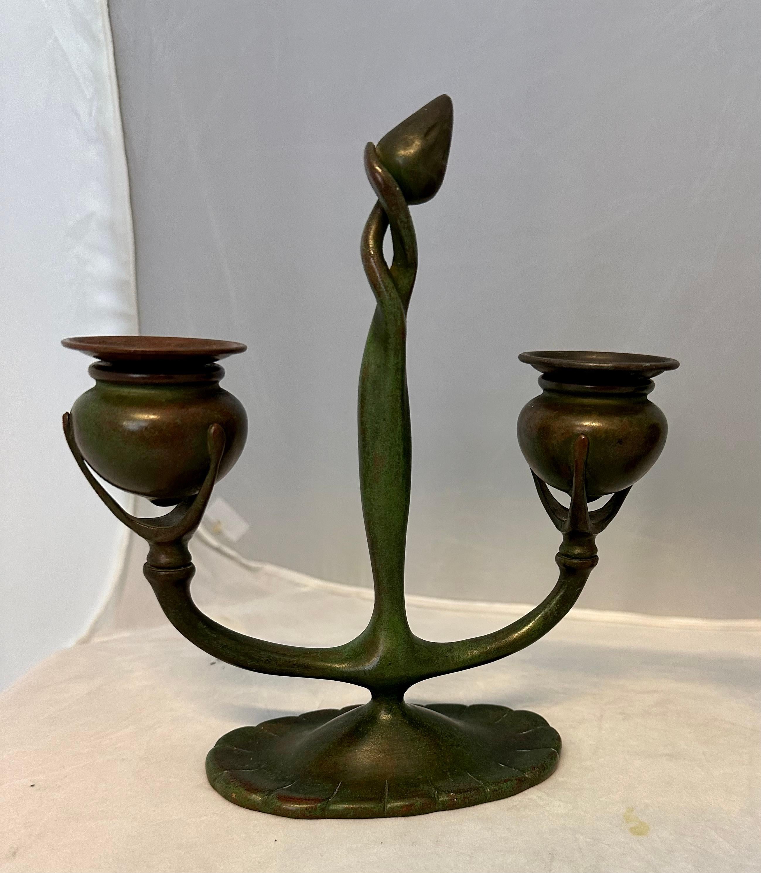 Estos candelabros vintage de doble brazo de principios del siglo XX de Tiffany Studios, Nueva York, están bellamente diseñados y conservan su superficie patinada original. Están excepcionalmente esculpidas con dos brazos extendidos, cada uno de los