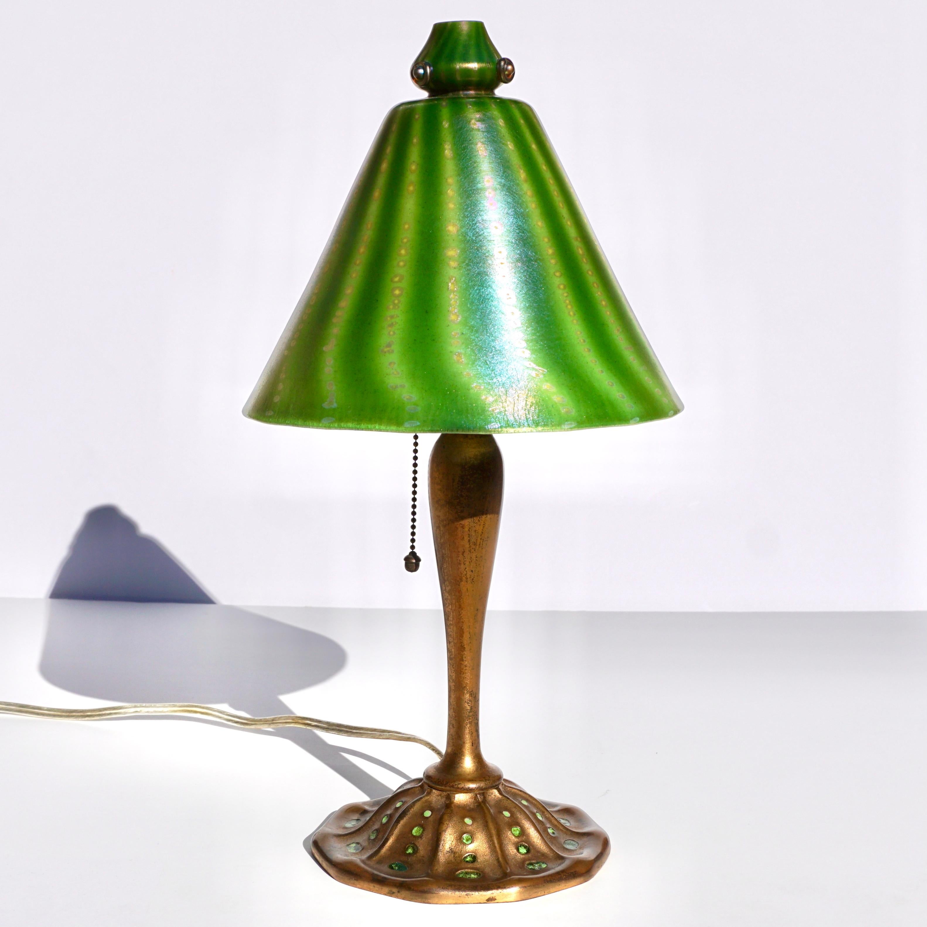 Tiffany Studios Favrile and bronze Aladdin desk lamp.

A beautiful Favrile glass and bronze desk lamp by Tiffany Studios. The conical shade with alternating bands of dark and light green with iridescent accents, with a pattern of gold, iridescent