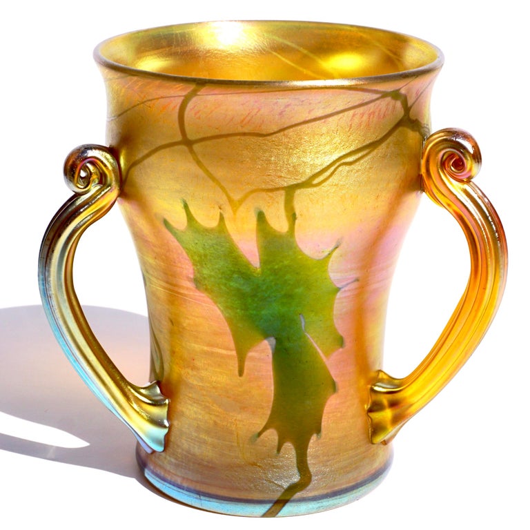Tiffany Studios Favrile decorated glass loving cup with three coiled handles. 
Circa 1910
Engraved 