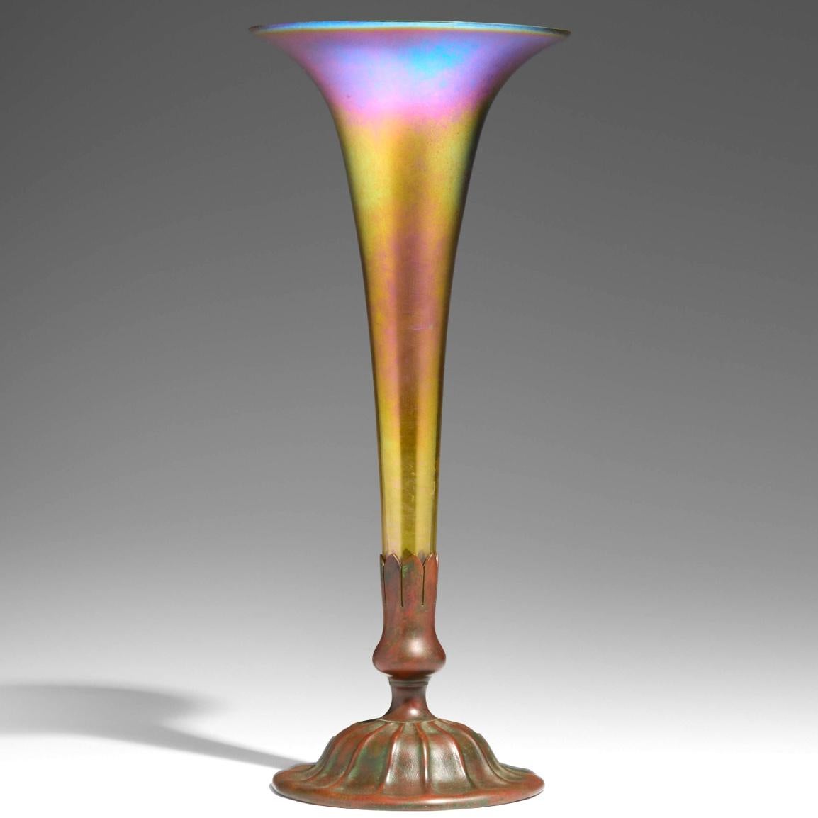 Jarrón trompeta de favrile iridiscente y bronce de Tiffany Studios
EEUU, Nueva York. circa. 1920
Vidrio Favrile soplado a mano, bronce patinado
Altura: 14,75 pulgadas X 6,5 pulgadas de diámetro  (37 × 17 cm)
Estado: Excelente. Un arañazo en el
