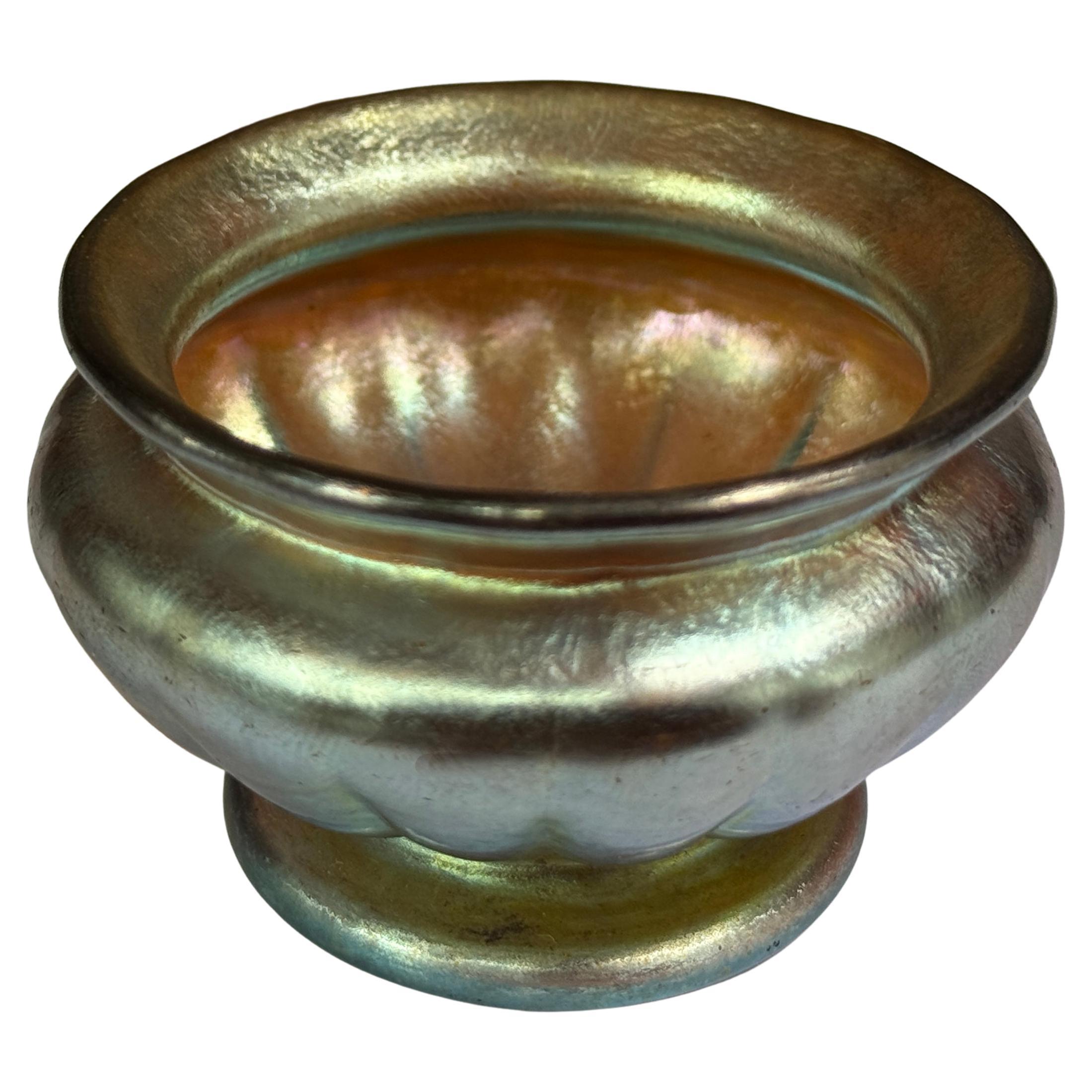 Louis Comfort Tiffany,irisé d'or, en forme de chaudron avec une base nervurée avec une marque de pontil poli. Signé A.I.C.A. sur le bord inférieur. Studios Tiffany. 1907. 1.5