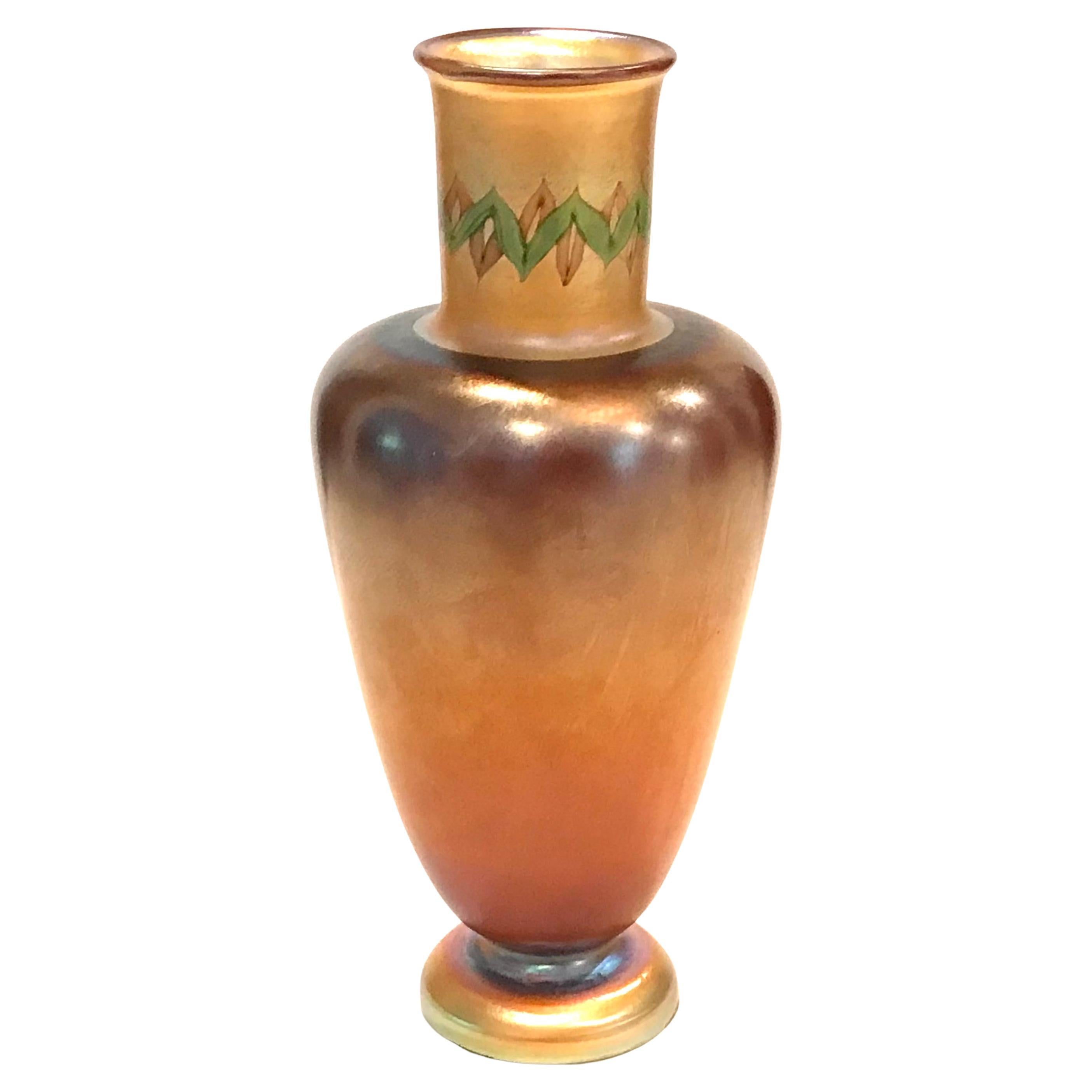 Vase à pied en Favrile Tall Tel El Amarna Iridescent de Tiffany Studios.
Vase Tel-el-Amarna
New York, USA, c. 1911-12
Verre Favrile soufflé à la main
Dimensions : 10 pouces de hauteur X 4,5 pouces de diamètre  (25 × 11 cm)
Signé sous le pied :