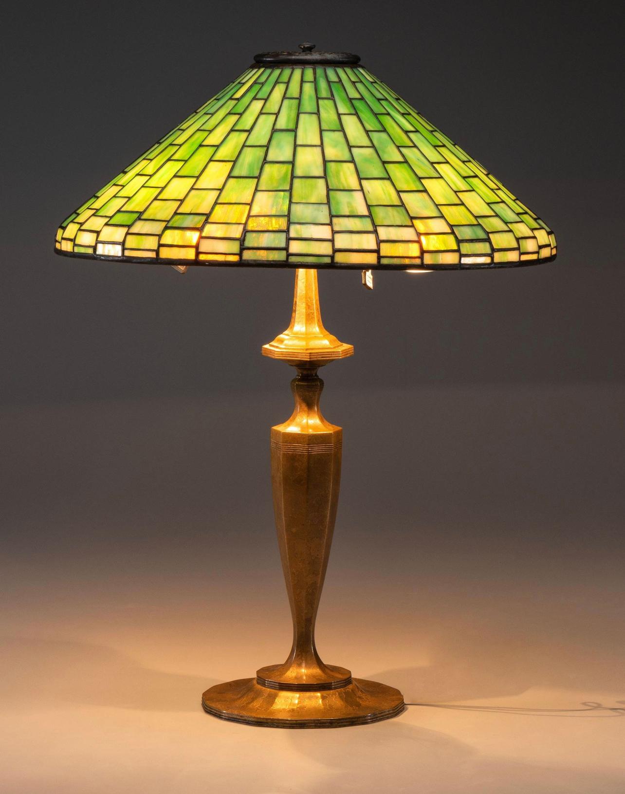 Tiffany Studios leaded glass and gilt bronze table lamp. A rare and large 18 Inch diameter green leaded glass plain square cone shade with geometric design sits on a 24 Inch high gilt bronze Art Deco classical distinguished table lamp base.