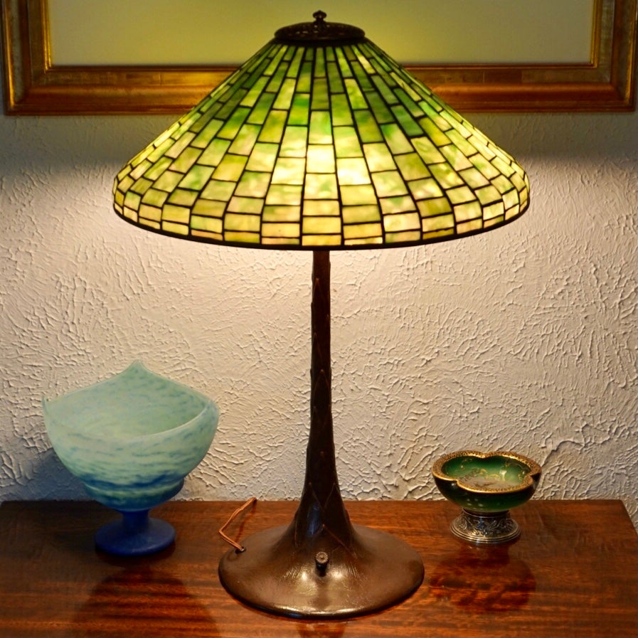 Tiffany Studios Geometrische und Bronze Tischlampe. Jugendstil CIRCA 1910

Schöne Tischlampe aus Bleiglas von Tiffany Studios. Der Schirm mit einem Durchmesser von 18 Zoll besteht aus einem geometrischen Muster aus gestreiftem und gesprenkeltem