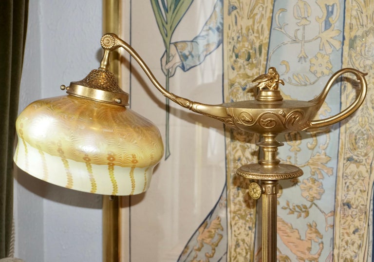 Tiffany Studios Gilt Bronze and Favrile Glass Aladdin Floor Lamp. Gilt gold plated bronze depicting Aladdin’s lamp with handle emitting a plum which produces a beautiful and rare golden yellow and orange damascene fluted cased glass shade made by