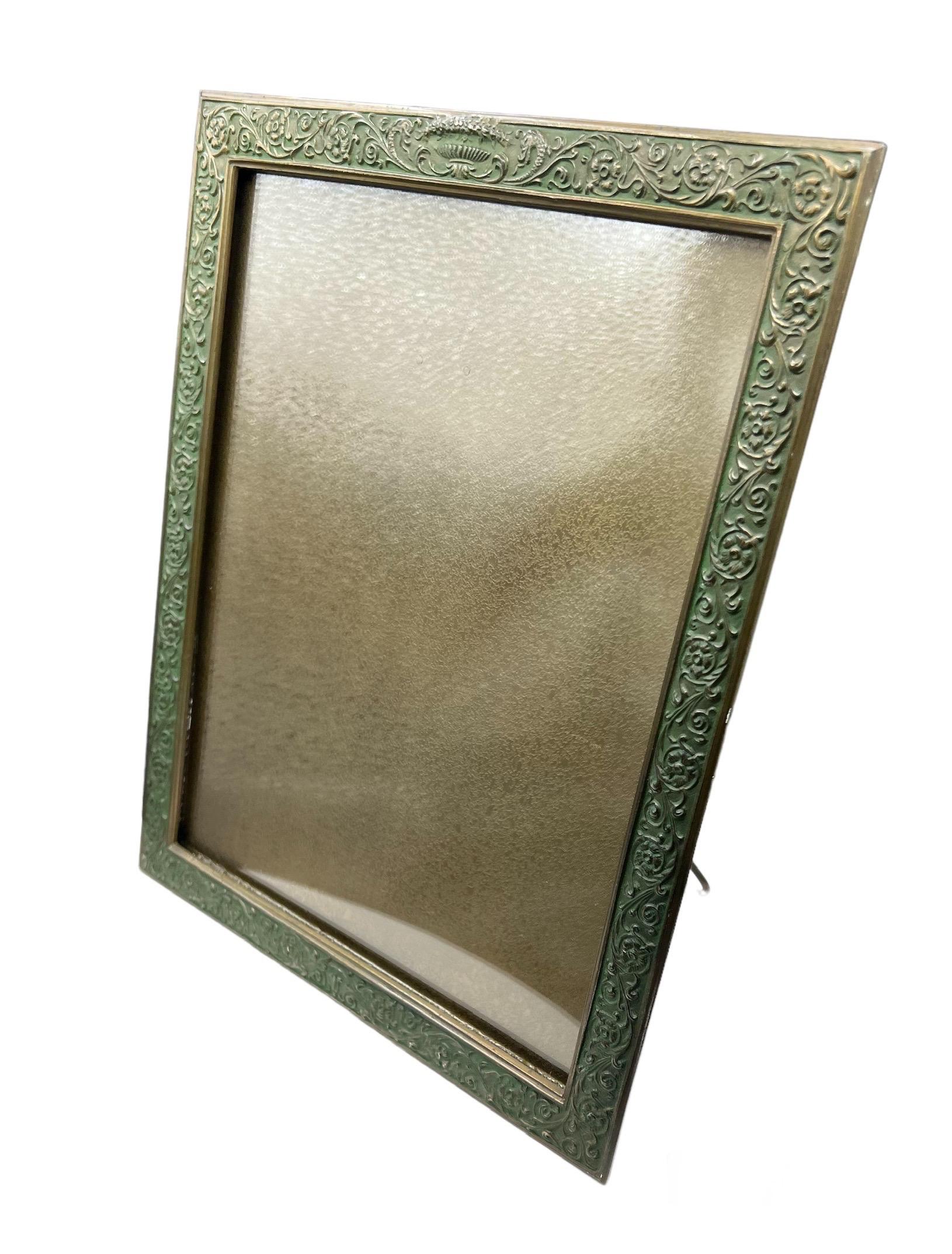 This Tiffany Studios gilt-bronze picture frame, 
Stamped Tiffany Studios / NY / 1611.  In the 