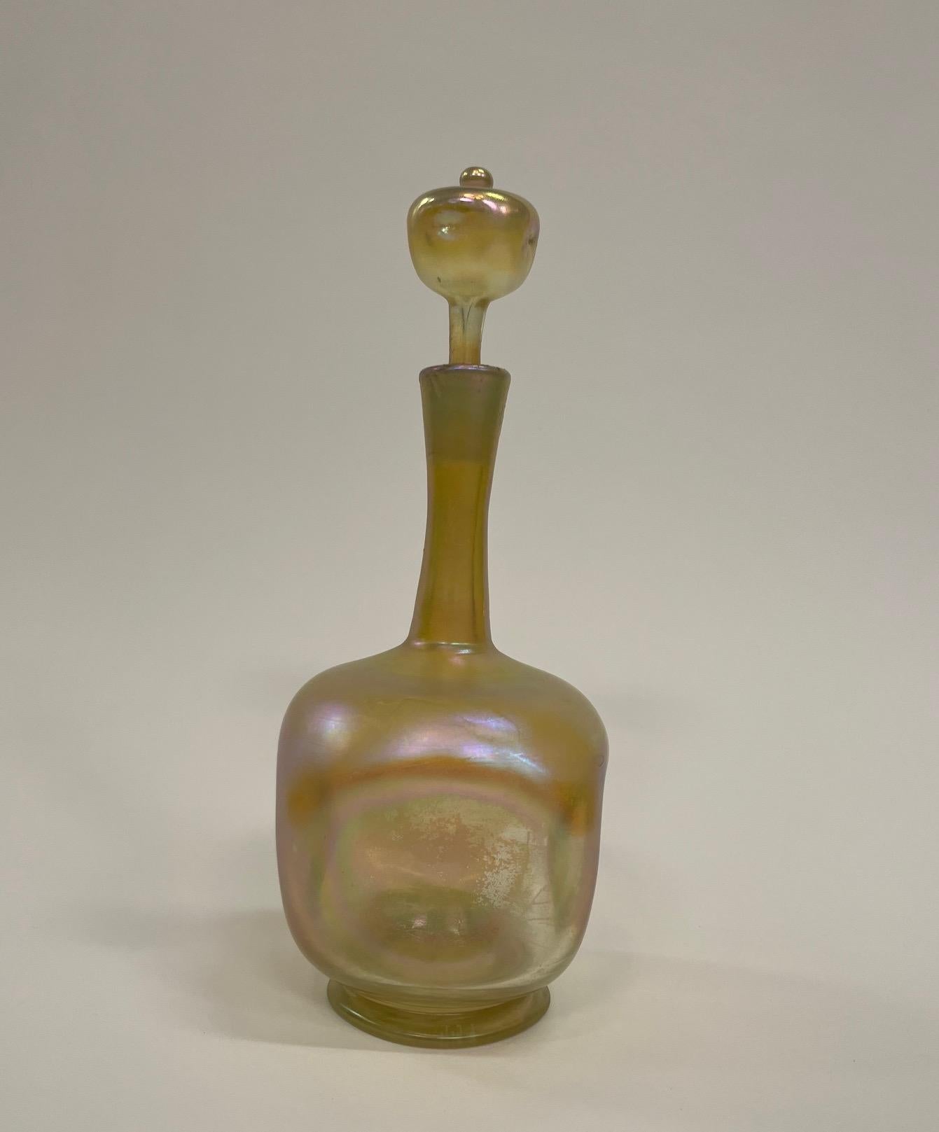 A Tiffany Studios iridescent Gold Favrille Decanter and Stopper
4 rounded concave sides surmounted by a scepter shaped stopper
Signed L.C.T and numbered