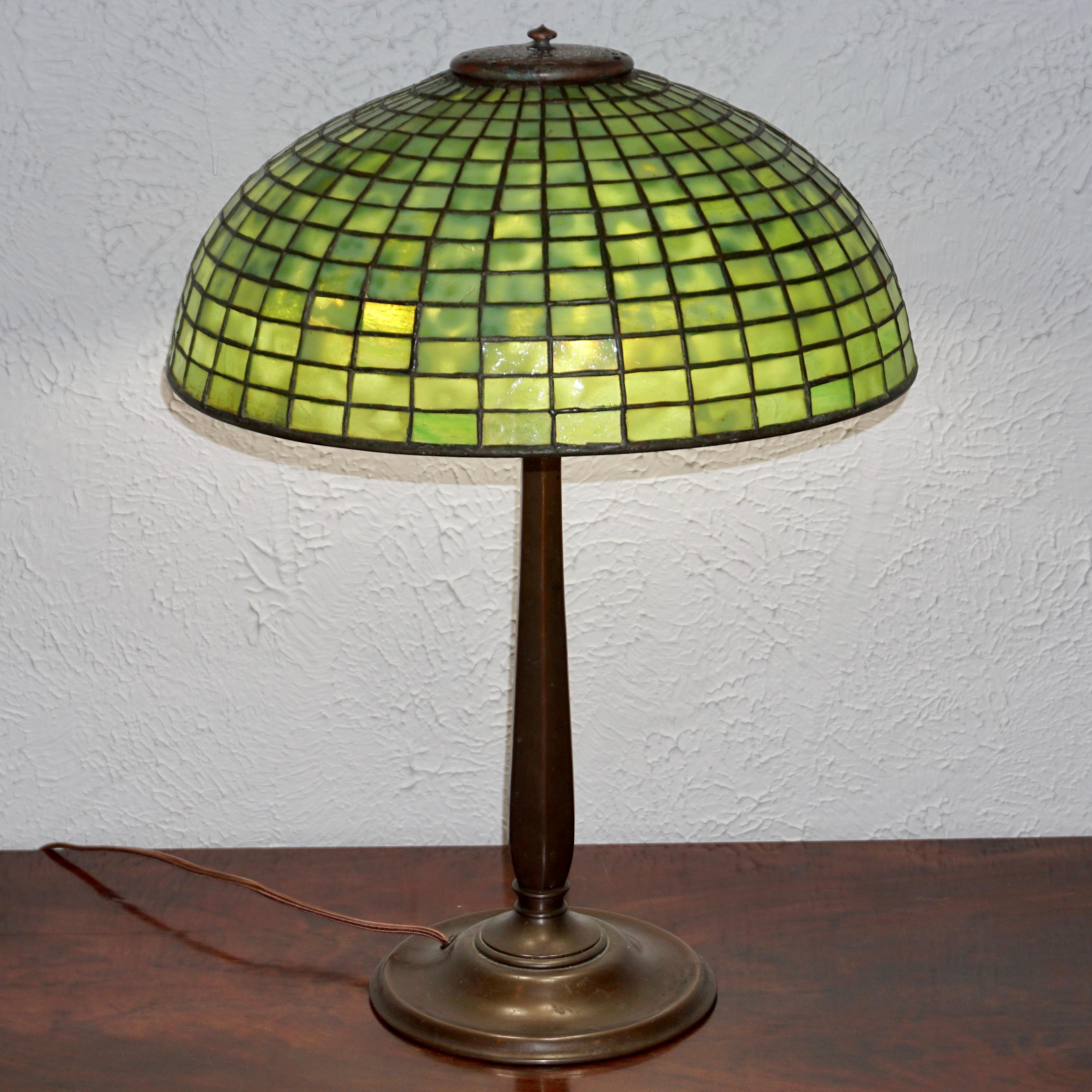A great Geometric Tiffany Studios table lamp, circa 1910

From the Art Nouveau era comes this simple yet elegant Tiffany Studios lamp. The shade with monochromatic glass panels align to make a geometric pattern emitting a wonderful warm green hue