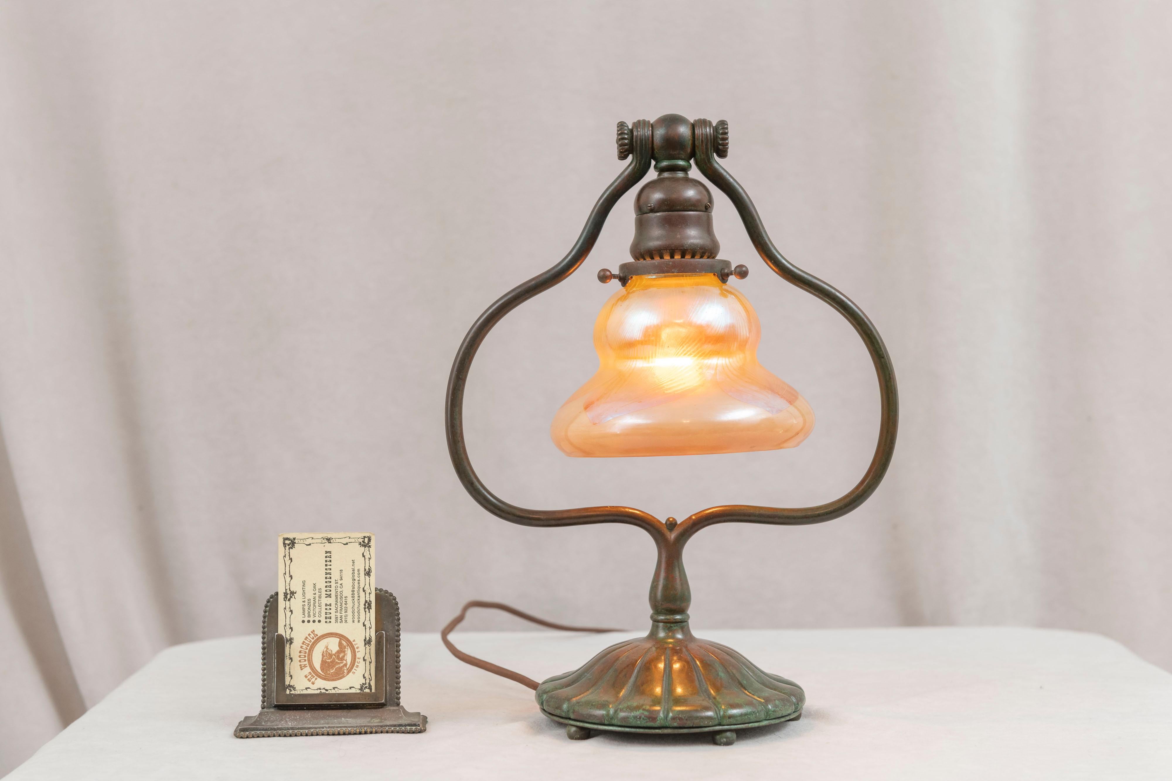 This is an authentic antique Tiffany & Co. Studios lamp. The bronze base which supports the shade can be adjusted to the angle of your preference. The shade is signed 