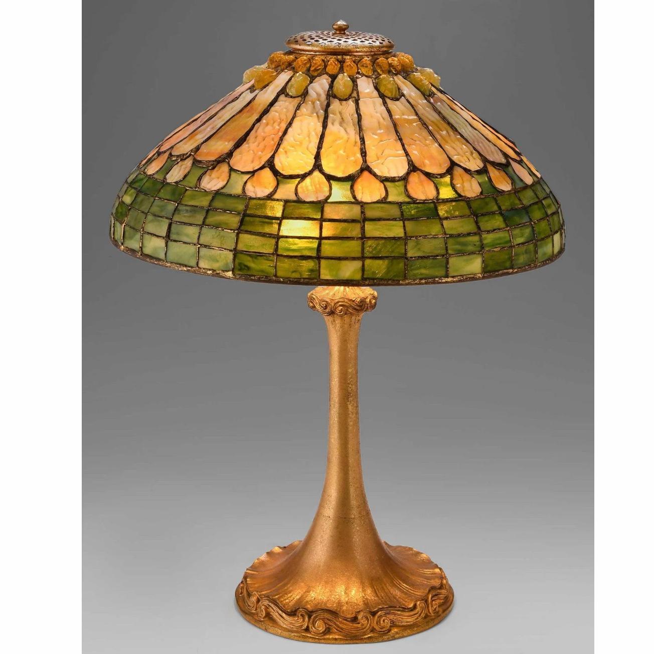 Tiffany Studios Jeweled Feather Table Lamp.

New York, Circa 1910 
Base signed TIFFANY STUDIOS NEW YORK 584, Height 22 Inches
Shade signed TIFFANY STUDIOS NEW YORK 1439, Diameter 16.25 Inches

Mottled glass shade in variegated cream, green, and