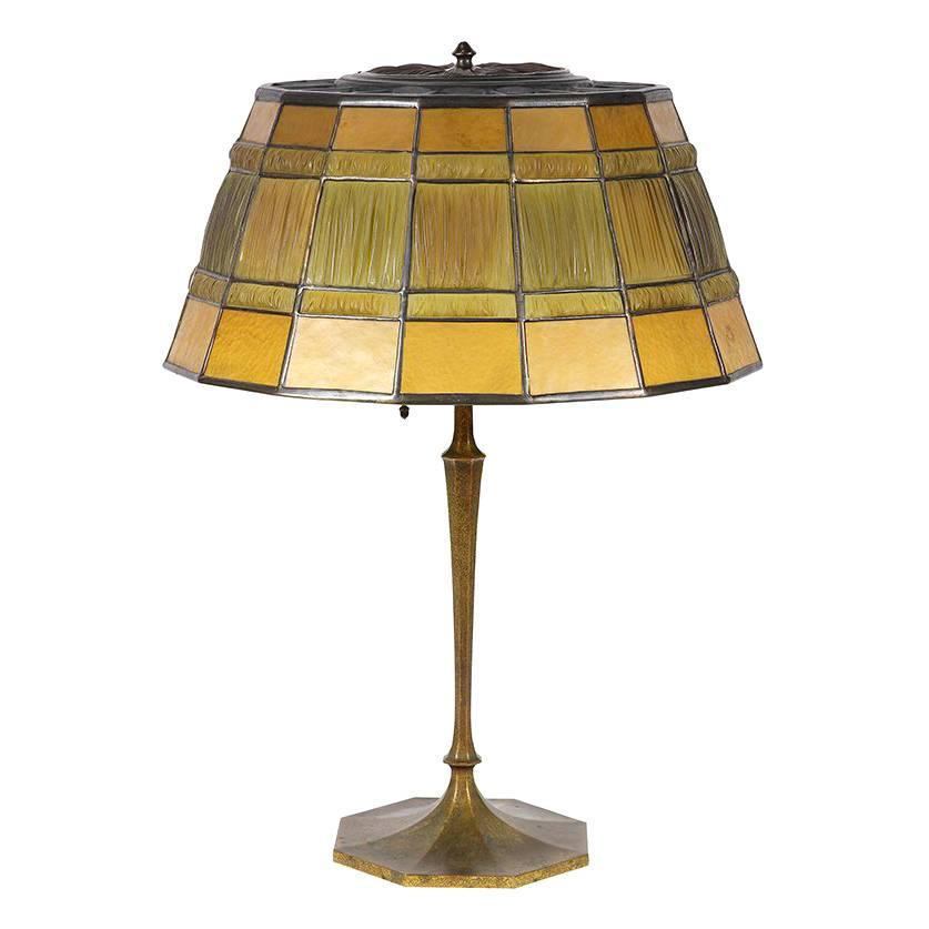 A Tiffany Studios linen fold table lamp made of dore bronze and gold glass panels,

made in New York,
circa 1910.
Stamped: Tiffany Studios-New York.