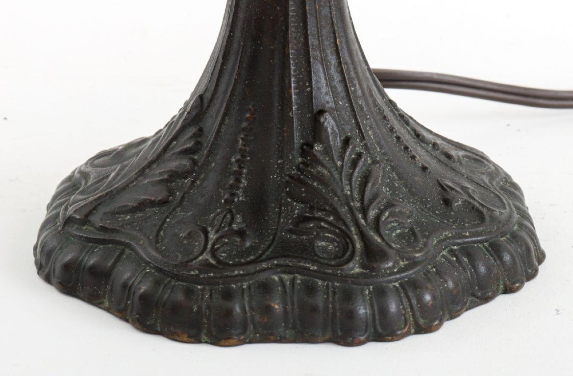 Lampe de table d'appoint avec un abat-jour en verre teinté à la manière des studios Tiffany, montée sur une base en bronze patiné, vers la fin du XXe siècle. 