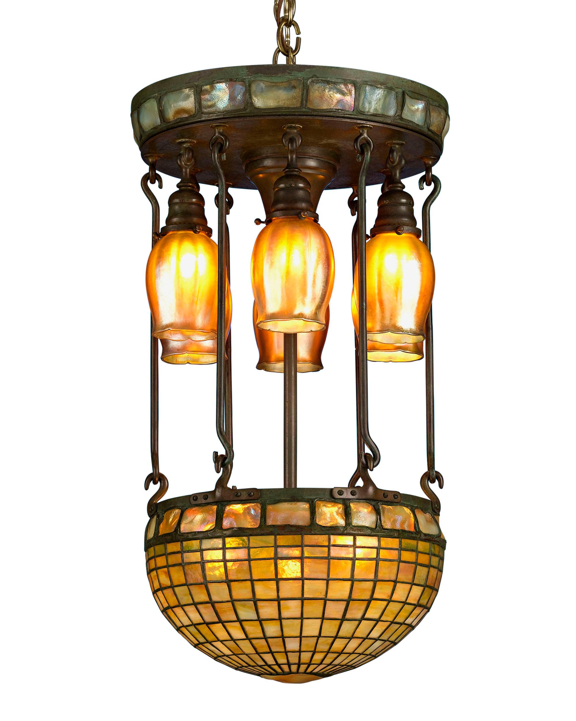 This important Tiffany Studios chandelier is crafted in a Moresque, or Moorish, Turtleback Tile motif, and is representative of Tiffany's most desired exotic geometric designs. This particular example exhibits a highly desirable blend of rich amber