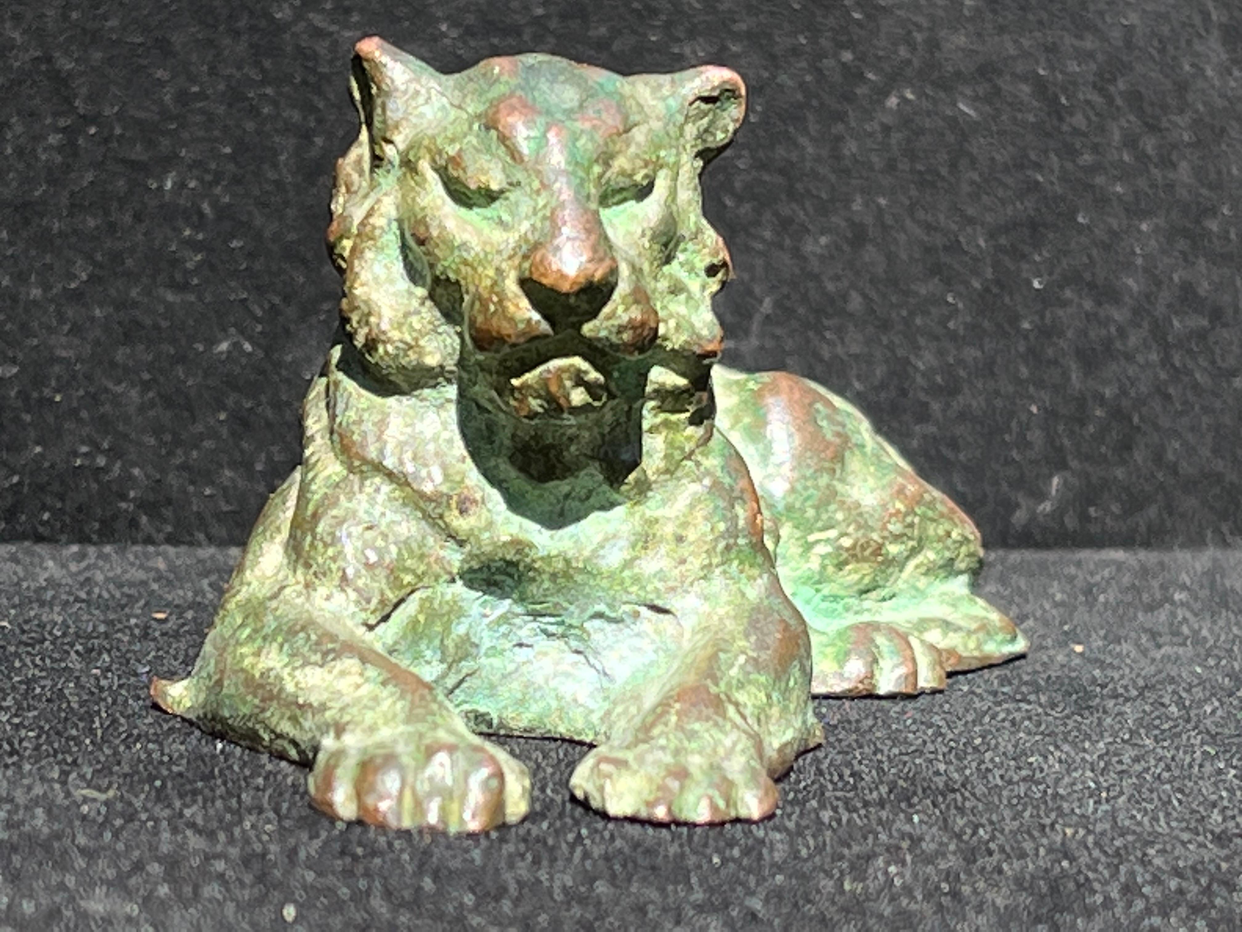 An early 20th Century Tiffany Studios New York recumbent lion in bronze with a verdigris patina. This proud animal sculpture is stamped on the underside and also has the model number 932. Tiffany Studios was in operation from approximately 1902