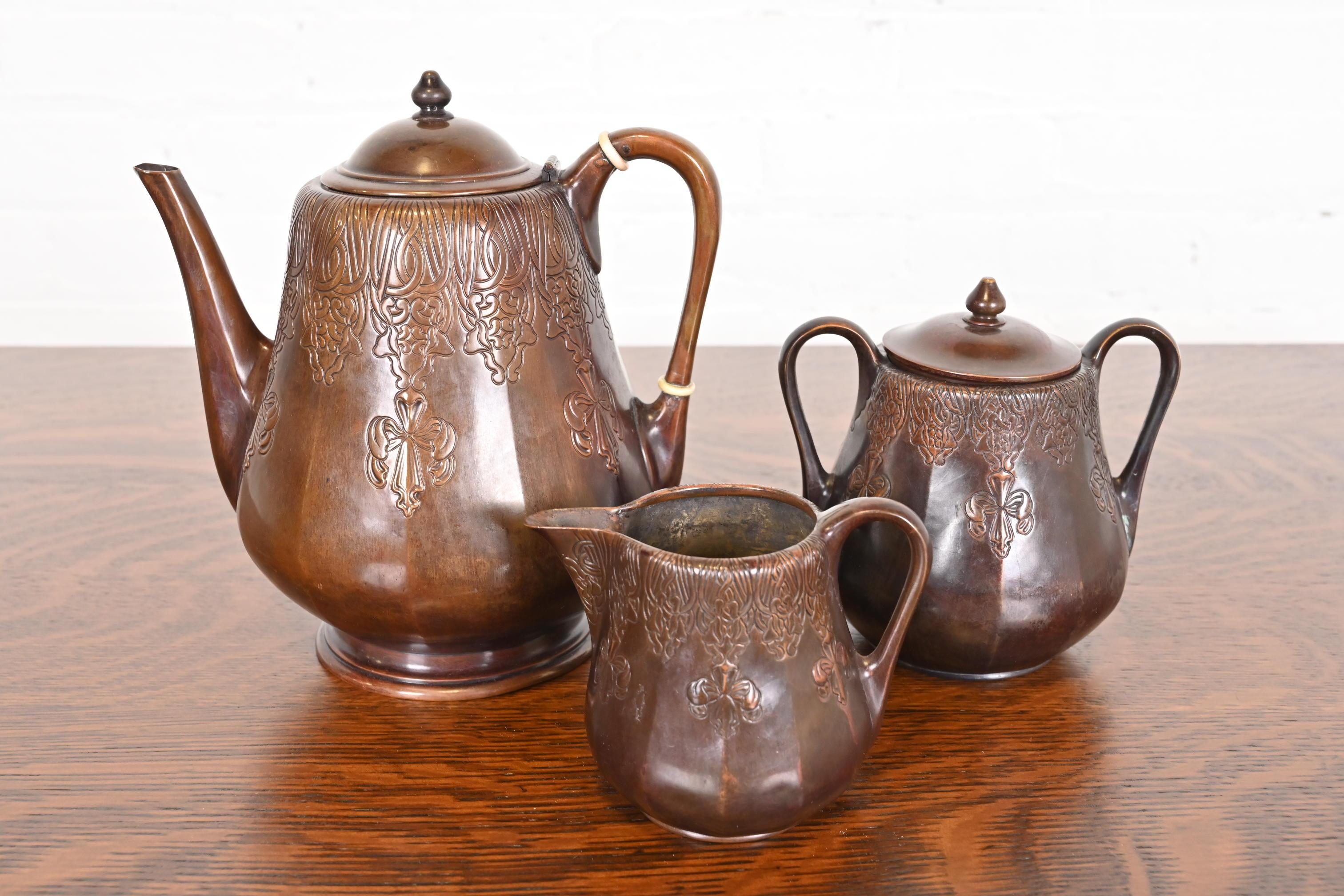 A gorgeous Arts & Crafts period copper tea or coffee kettle, sugar bowl, and creamer

By Tiffany Studios (signed to the underside)

USA, Circa 1910

Measurements:
8.25